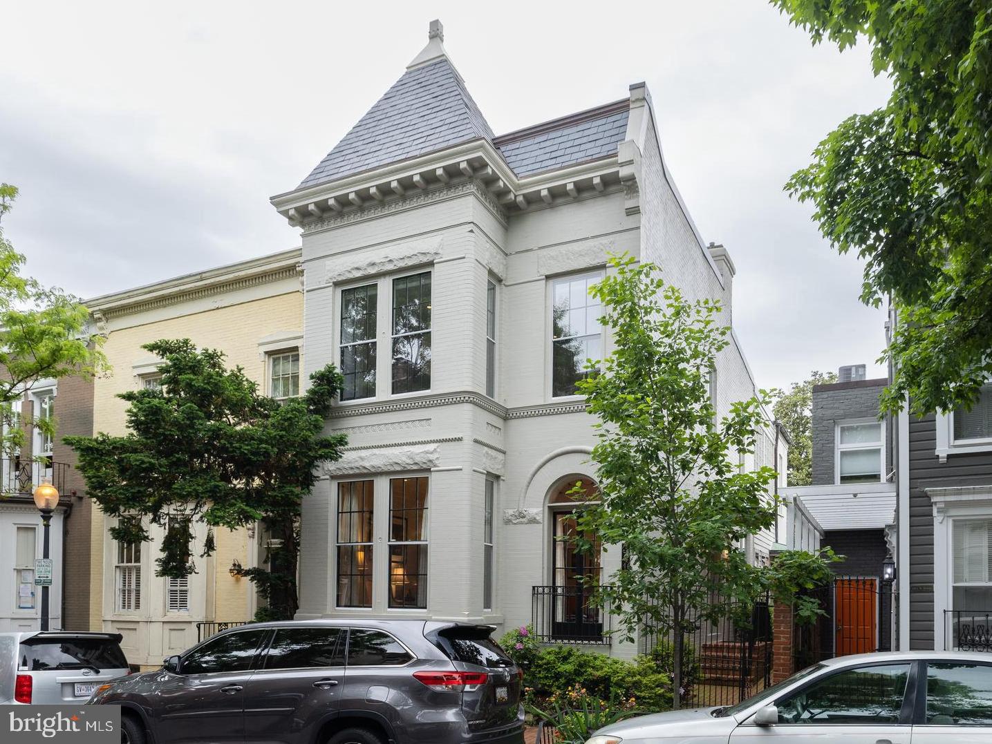 This prime Georgetown property is situated on a beautiful, historic block in the West Village. Just steps away from M Street and close to Wisconsin Avenue, it has easy walking access to all the high-end shops and fine dining the neighborhood has to offer.
 
This bright, semi-detached house is the epitome of a discriminating buyer’s wish list with natural light streaming in from three sides throughout the home, a two-car garage, two-level living, and architectural authenticity. Original floors, high ceilings, and lovely moldings add to the home’s original character while serving as a wonderful setting for contemporary art and furniture. Tasteful renovations and updates have been thoughtfully incorporated throughout the home and include a family room overlooking the beautiful, cultivated garden that surrounds the patio and lines the walkway from the front sidewalk.  
 
The main level opens from a covered side entrance to a generous entry hall, with coat closet, that opens to a large living room with an oversized bay window with window seat, French doors with a Juliet balcony and leaded fantail detail, built-ins, and a ventless gas fireplace with marble detailing. The formal dining room on the right of the front door features elegant details, including a built-in corner cabinet, large window, and a sizeable contemporary chandelier. The gourmet kitchen is equipped with stainless steel appliances, including a six-burner Wolf range, a Ventahood vent, a Sub-Zero French door refrigerator/freezer, a Bosch dishwasher, an Asks dishwasher, and a Beko built-in microwave. It also has granite countertops, and a marble backsplash. The attached family room with powder room is perfect for relaxing and entertaining, with built-ins and two sets of double French doors leading to the private back garden. The garden has a herringbone brick terrace, mature plantings in raised beds including crepe myrtles and dogwood trees, and Rain Bird irrigation and Alliance exterior lighting.
 
Upstairs, the grand primary suite boasts multiple windows with window seats, built-ins, and closets, including a separate walk-in closet. The primary bath features dual vanity sinks, a frameless glass steam shower, and a separate soaking tub. The second bedroom, currently used as an office, has built-in shelves and an en suite half bath. The third bedroom, currently used as a beautifully designed library, has a bank of west-facing windows with a dramatic 96 panes of glass and built-in bookshelves as well as a walk-in closet. The fourth bedroom, on the corner, has built-in bookshelves, and is flooded with light from west and south-facing windows with a full bath next door. A recently renovated lower level adds a guest suite kitchenette with small refrigerator and small freezer, a full bath, a washer/dryer and laundry area with ample storage cabinets and shelves, as well as a room that can become a bedroom. Beyond the garden terrace is a full-sized, two-car garage with additional built-in storage and alley access from 34th and 35th Streets. Next to the garage is a dedicated garbage area with space for six full-sized trash cans for everyday ease separated by a gate from the patio.
 
Nearby Volta Park, with its pool and tennis courts, is a wonderful green space, and the house is conveniently located with easy access to Trader Joe’s, Whole Foods, and a Safeway grocery store. The Key Bridge, Georgetown University, and both Reagan National and Dulles International Airports are easy to get to as well.