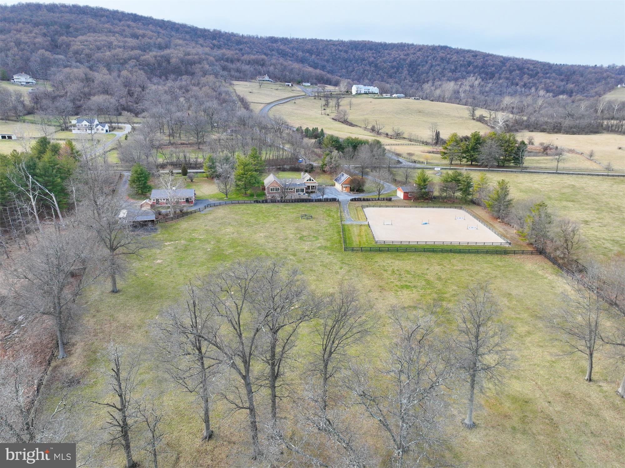 Welcome to Dogwood Farm, a fabulous equestrian property on 13+ acres with miles of ride out!  Your horses will be living the life with the 4 stall center aisle barn with wash stall w/hot & cold water, fans on thermostats, heated automatic waterers, tack room, feed room, and laundry room w/washer & dryer, stall cameras, hay loft, covered sawdust bin, 150 ft. x 125 ft. riding ring with Equifibre footing, 2 large pastures w/automatic waterers and run-in sheds with fans on timers, 3 board fencing, room for trailer parking, All this and a gorgeous custom log home with approximately 3500 sq. ft. of living space and a detached 3 car garage PLUS another detached 2 car garage (total 5 garage spaces). One level living at its best: generous size primary suite with jetted tub, separate shower, dual vanities and two closets, including one walk-in; 2 secondary bedrooms (one with ensuite bath) and both have doors to covered front porch; laundry all on main level. Chef's dream kitchen with center island, upgraded stainless appliances, granite counters and beautiful white cabinetry. Keep an eye on the horses while sipping your coffee at the large breakfast bar with 4 large windows overlooking the pasture and riding ring. Kitchen opens to generous sized dining room with double sliders leading to the spacious stone patio, perfect for al fresco dining or enjoying your evening beverage. Huge great room with stone gas fireplace, beamed cathedral ceiling, wall of built-in bookcases, six skylights---ideal for entertaining and large gatherings, A wonderful mud room and a third full bath with walk in shower round out the main level. A 4th bedroom/office is upstairs with skylight, built-ins, more great views. Gleaming wood floors, tons of natural light  from the many large windows and skylights (6 in great room, one in dining room, one in kitchen, one in 4th bedroom/office), built-in bookcases, recessed lights, beamed and cathedral ceilings and the meticulous care the current owners have taken make this a property you won't want to miss. 3 hot water heaters (one dedicated to barn), two zone HVAC, solar panels (owned outright), Generac generator to power house and barn during outages, invisible dog fence. Current owner upgrades since 2014: new roofs on house (except flat rubber roof over kitchen/dining room), barn, & all buildings; new skylights, replaced HVAC systems & humidifier, updated kitchen and hall bath,  water softener and well pump, solar panels, generator. Starlink available for internet.