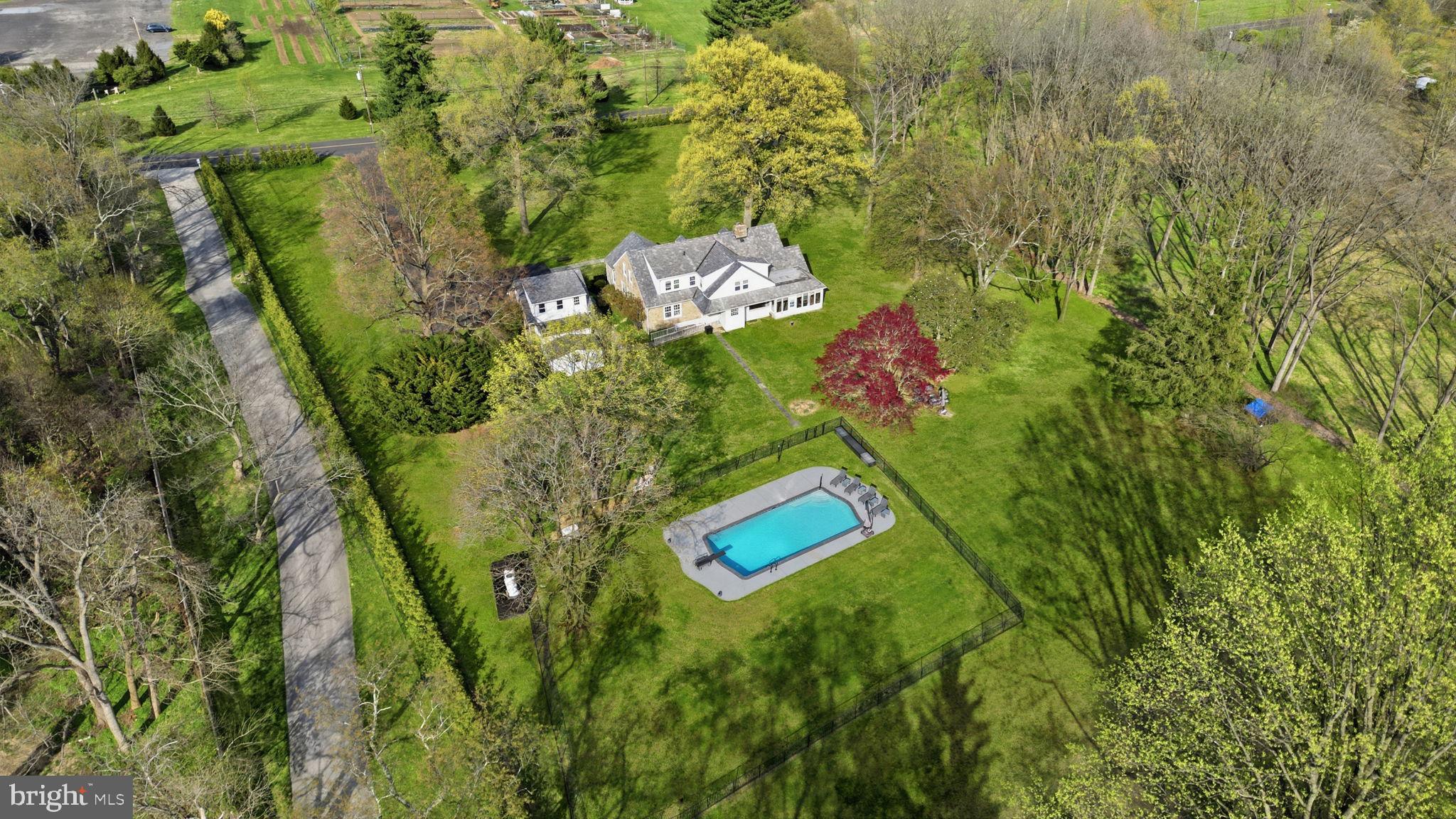 Welcome to Huntingdon Valley — a charming stone Cape Cod set on nearly 3 acres with breathtaking views. This custom-built home offers approximately 4,000 sq ft of living space and is ideally located near Lorimer Park and the Pennypack Trail. Set back from the road down a long private driveway, the property features 5 bedrooms and 3 full bathrooms. The main level opens with a grand foyer showcasing hardwood floors and a statement chandelier. The formal living room is filled with natural light from oversized picture windows and features a full stone fireplace, exposed beam ceiling, recessed lighting, custom built-ins, and French doors leading to the side yard. The formal dining room offers elegant built-in servers with marble tops, crown molding, and access to a bright sunroom with stone flooring, wood and stone accents, and access to the rear patio. The kitchen includes a large island with granite countertops, stainless steel appliances, and a breakfast area overlooking the expansive backyard. Also on the main level is the primary suite with ample closet space and private bath, along with a second bedroom and full hall bath. The second floor includes two generously sized bedrooms, a full bath, a large walk-in attic, and a versatile fifth suite with vaulted ceilings—perfect for a playroom, office, or gym. Step outside to your private retreat featuring a brand new, fully updated in-ground swimming pool, surrounded by ample patio space—perfect for entertaining and enjoying the peaceful setting. Additional features include a detached 2-car stone garage with ground-level storage, a second-floor space with balcony potential, and architectural details such as hardwood floors, crown molding, chair rail, paneled doors, and exposed beams. Recent upgrades include newer windows, newer granite countertops, Upgraded Well System, Newer HVAC and hot water heater, with over $190,000 in improvements. Possible subdivision or addition of outbuilding makes possibilities endless for developer, contractor! Don’t miss this opportunity before it’s gone!