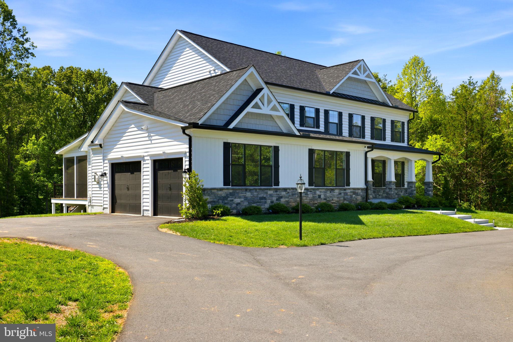Built in 2023 and presenting like new, this stunning Sullivan Reserve home offers over 4,600 square feet of thoughtfully designed living space on a private 3.55-acre corner lot with a 300-foot circular driveway and classic lamp post. Featuring 5 legal bedrooms and 3.5 baths, the home includes 3,218 square feet above grade plus a 1,394 square foot finished basement, along with an oversized 4-car tandem garage with epoxy flooring. Inside, all three levels boast 9-foot ceilings and engineered hardwood flooring throughout, creating a seamless and elevated feel. The main living area is anchored by a beautifully upgraded kitchen with an oversized picture window, quartz surfaces, wine bar, and coffee bar nook, complemented by custom staircase railings and modern lighting fixtures throughout. The primary suite offers a true retreat with vaulted ceilings and a spa-inspired bathroom featuring a steam shower with massage functions and body sprays. Outdoor living is exceptional with a fully covered, all-seasons enclosed space featuring barn-style sliding screened doors, an extended deck, and a cascading staircase leading to the expansive, pool-capable yard. Additional features include black exterior windows and gutters along the front elevation, a whole-home water softener treatment system, and well and septic. Ideally located in a private and peaceful setting with convenient access to I-95, Quantico, and shopping, and zoned for top-rated Stafford County schools including Margaret Brent Elementary, Rodney Thompson Middle, and Mountain View High School.