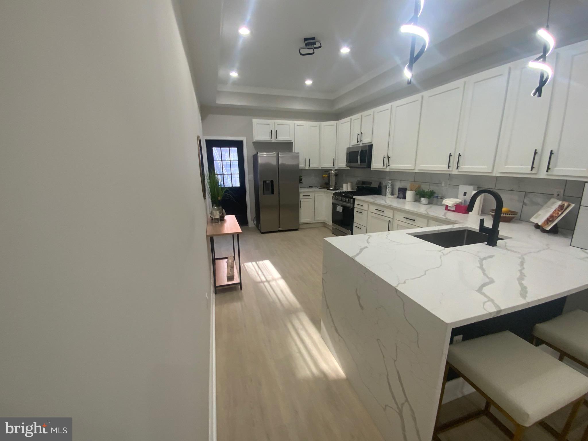 Nestled in the prestigious Druid Heights neighborhood, this exquisite Colonial townhouse, originally built in 1920 and set for a major renovation in 2025, seamlessly blends timeless elegance with modern luxury. The property boasts a striking brick façade that exudes classic charm while promising a sophisticated lifestyle for discerning homeowners. Step inside to discover an open floor plan that invites natural light to dance across the luxury vinyl tile and ceramic tile flooring. Outfitted with high-end stainless steel appliances-including a built-in microwave, cooktop, dishwasher, and refrigerator-this kitchen is designed for both style and efficiency. The recessed lighting enhances the ambiance, creating a warm and inviting atmosphere for entertaining. Adjacent to the kitchen, the dining area offers a perfect setting for intimate dinners or lavish celebrations, all while maintaining a connection to the heart of the home. The thoughtfully designed breakfast area provides a cozy nook for morning coffee, allowing you to savor the tranquility of your surroundings. The property features double-hung, double-pane windows that not only enhance energy efficiency but also frame picturesque views of the neighborhood. The absence of a fireplace allows for a clean, modern aesthetic, while the carbon monoxide detectors ensure peace of mind in this luxurious haven. With an attached rear-entry garage and additional off-street parking, convenience is paramount. The property's excellent condition reflects meticulous care and attention to detail, making it a perfect canvas for your personal touch. This home is not just a residence; it's a lifestyle. The Druid Heights community offers a serene environment, ideal for those seeking a blend of urban convenience and suburban tranquility. Enjoy the freedom of no association fees and the absence of community amenities, allowing you to curate your own exclusive lifestyle. As you envision the possibilities that await in this remarkable property, consider the unparalleled opportunity to own a piece of history, reimagined for modern living. This is more than just a home; it's a statement of luxury and sophistication, ready to welcome you into a world of elegance and comfort. Baltimore City's Grant Initiatives Available!