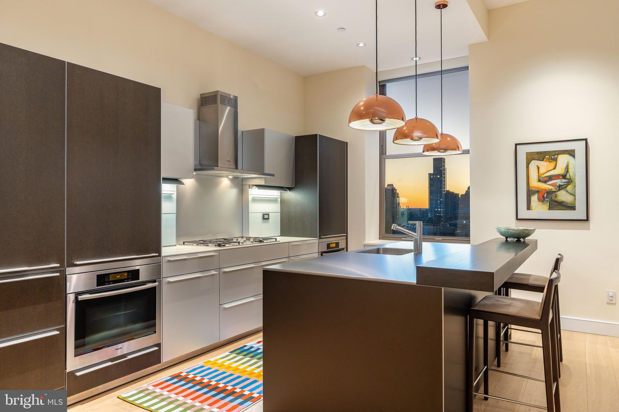 NEW LISTING | Exceptional Modern Masterpiece at The Ayer

Live the life you deserve in this architectural gem at the prestigious Ayer Condominium, perfectly situated on historic Washington Square in Society Hill. This stunning corner residence blends timeless design with exquisite modern upgrades, showcasing soaring 11’7” ceilings, incredible natural light, and wide-plank white oak flooring throughout.

The expansive Great Room offers two distinct seating areas and has a dramatic setting for entertaining, complete with a dining area that accommodates 20+ guests. A newly installed Porro rosewood media wall integrates a Bang & Olufsen audio system, a 77” LG OLED TV, and gallery-style glass-lit display shelves—ideal for art collectors.

The bulthaup-b3 kitchen is a chef’s dream, reimagined with a sleek stainless-steel island, breakfast bar, there is a pretty white marble powder room, Miele and Sub-Zero appliances, and abundant storage—equal parts form and function.

The Primary Suite is a serene retreat with custom closets, new flooring, and a luxurious marble bath featuring an oversized walk-in shower. The second bedroom’s 10:6 ceiling height boasts an en-suite stone bath and a generous closet space. A third flexible room, ideal as an office or guest suite, enjoys natural light and custom-built-ins.

Smart home automation controls lighting, shades, and sound throughout.

Residents enjoy access to 6-star amenities, including:

Hotel-style concierge

Valet parking at your door

Chauffeur-driven hybrid BMW

State-of-the-art fitness center

Common terrace with herb garden

On-site management

One on-site garage parking space with EV charging is included in the sale and covered by condo fees. [SUV spaces are limited]
