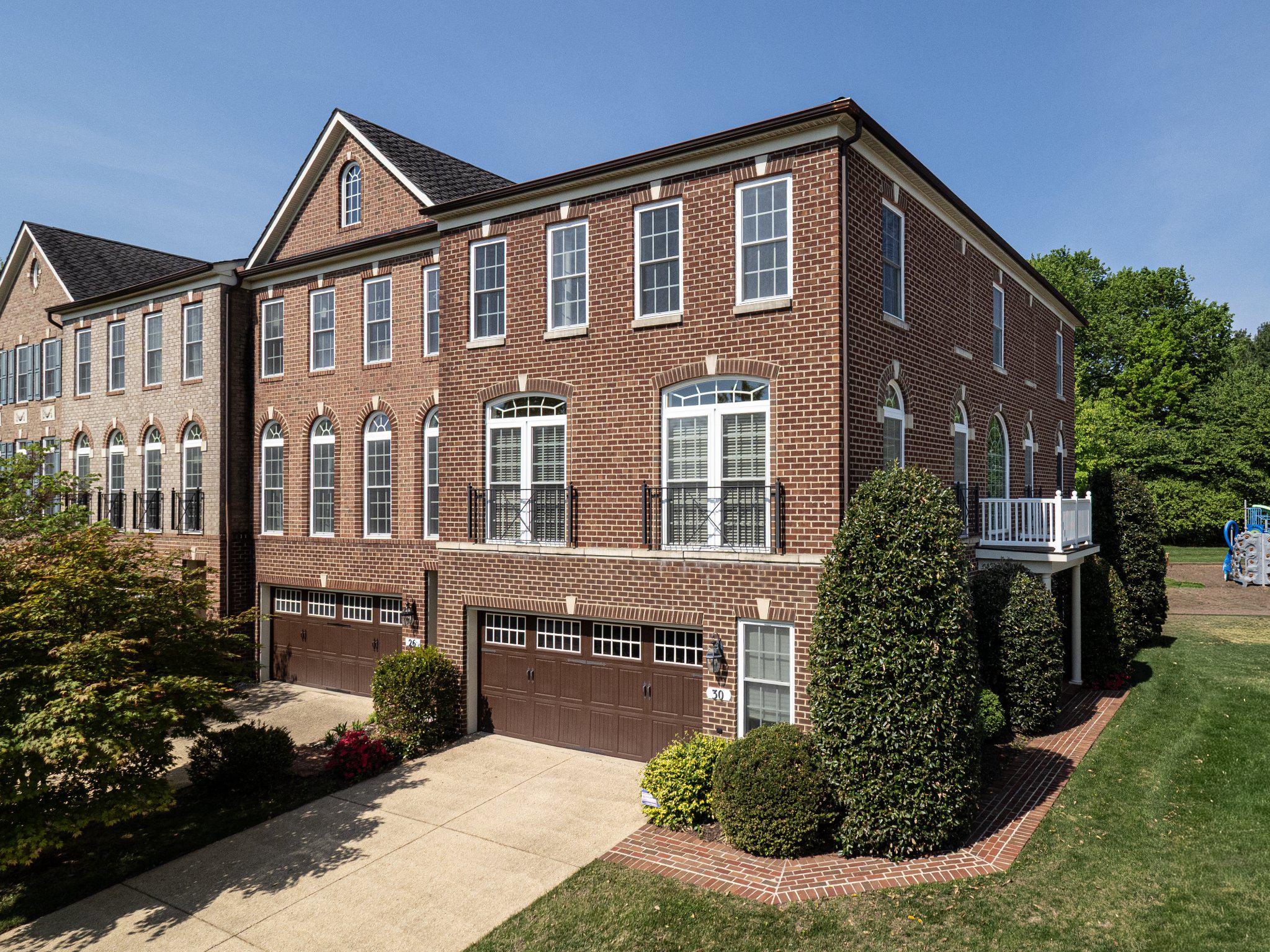 This exquisite brick townhome has nearly 3,000 sq feet of immaculate living space.  The entry level features an expansive recreation area with a fireplace, full bath and oversized two-car garage. Reaching the main living area, you are welcomed by sun-drenched living areas with rich hardwood flooring, extensive moldings and architectural columns. The formal living and dining rooms share an open area perfect for grand entertaining. The spacious kitchen shares space with a breakfast area and family room. The kitchen has cool granite countertops, premium hardwood cabinetry and stainless steel appliances. Enjoy serene green space from the back deck which is accessed from the breakfast area. The upper level features three bedrooms, a hall bath and laundry room. The owners’ suite is an oasis with a tray ceiling, oversized walk-in closet, and a sparkling private bath with premium ceramic tile flooring, dual vanities, and spa-like shower. Rarely does a townhome offer this combination of space, light, and location. As an end unit, it has an extra ten large windows that fill every space with natural light making it feel like a luxurious single family home. The location is minutes away from grocery stores, shops and entertainment at Rio, Crown and Kentlands. The property is currently assigned to Fields Road ES, Ridgeview MS and Quince Orchard HS. Starting the 2027-2028 school year, the assignments are planned to transition to Frost MS and Wootton at Crown HS. See MCPS for detailed information.