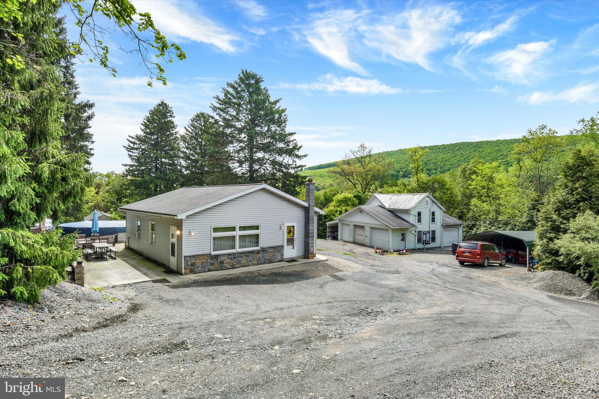 Welcome to 239 Hill Street in the heart of Lykens—an incredible opportunity on 3.19 acres with endless possibilities! This unique property features a newer ranch-style home offering easy one-floor living with 2 bedrooms, an open-concept layout, durable easy-care flooring, Anderson windows, and stainless-steel appliances. Step outside to enjoy the oversized patio, above-ground pool, and pool hut—perfect for summer entertaining while taking in scenic views and local wildlife.

The original home has been thoughtfully converted into an oversized four-bay garage complete with upstairs office and storage space, previously used for a landscaping business. The property also includes multiple sheds, covered metal garages, and ample room for hobbies, storage, or business use. A portion of the land is currently set up as a motocross track but could easily be transformed into garden space, recreational land, or hobby farming. Whether you're looking for space to work on vehicles, run a small business, create rental income potential, or simply enjoy country living with room to grow, this move-in ready property is packed with opportunity!