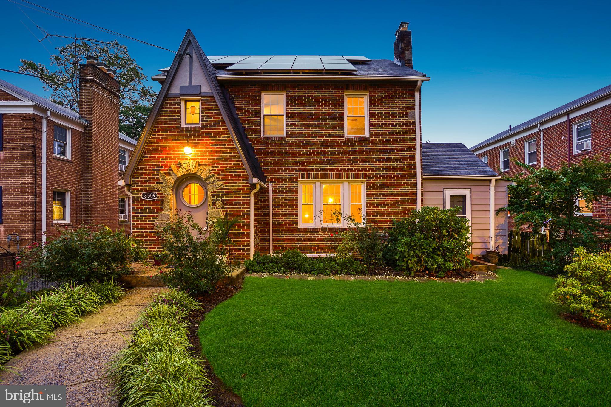 PRICE REDUCED FOR END-OF-YEAR SALE! This purely magical brick-and-stone Tudor blends timeless character with thoughtfully designed spaces that combine historic charm and everyday comfort. Built in 1937, this distinctive residence includes a bevy of bedrooms, four full bathrooms, and a detached two-car garage with a large, lofted bonus space.

Upon entry, you’re welcomed by a classic arched front door with a portal window, leading into engaging living areas. Four levels of striking architectural details include hardwood floors, vaulted ceilings, and refined lighting. The spacious living room features a stone fireplace and a built-in bar, while the dining room flows seamlessly for entertaining. The newly renovated kitchen impresses with solid-surface counters, custom cabinetry, a gas range, and stainless-steel appliances. The main level is complete with a bedroom/sunroom with vaulted ceilings and a fireplace, a full bathroom, and a cedar hall closet.

The second floor offers two freshly painted bedrooms and two updated bathrooms, including a primary suite with a stylishly renovated bath, and a wonderful upper level den. The third level provides versatile space for a playroom, guest area, or office. The lower level includes a bright recreation room, a full kitchen, a private bedroom/in-law suite, a full bathroom, laundry, and storage.

The home is enhanced with owner-owned solar panels and a newly installed (June 2025) mini-split air conditioning system.

Outdoors, the property features mature trees and lush landscaping with flowering plants and multiple crepe myrtles. Perennial gardens bloom year-round. The rear yard offers privacy and a secure space for relaxation and play, complete with a patio and brick fireplace. The fully insulated detached two-car garage includes a lofted bonus space above, with potential for conversion to additional living quarters or rental use.

This truly remarkable property offers wonderful urban living just moments from all the vibrant amenities of Takoma Park. This home’s location combines the best of urban accessibility with access to nature. Situated just steps to historic Old Takoma business district, blocks to the Sligo Creek’s bike and walking trails, parks, and playgrounds, Koma café, forthcoming Purple Line, and readily accessible to the Red Line metro. The home is in close proximity to downtown Takoma Park and downtown Silver Spring and all the amenities these locations offer, including restaurants, coffee shops, farmers markets, gyms, and live music venues.