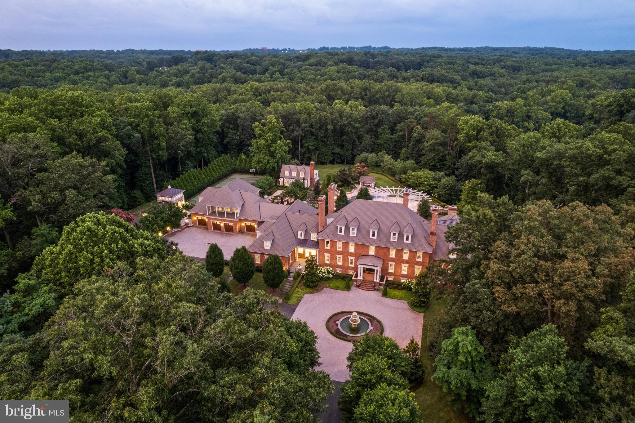 Welcome to Edgehill Estate—an extraordinary residence that embodies timeless elegance and modern luxury in the heart of Oakton. Set on 11 beautifully landscaped acres, this stately, oversize brick and stone colonial—inspired by the historic Carter’s Grove—offers over 20,000 square feet of meticulously designed living space. This grand residence masterfully blends classic American Colonial design with the highest level of modern luxury, technology, and artisan detail. 

Every inch reflects unparalleled craftsmanship—from hand-carved Chesney mantels imported from London to walls hand-painted by famed Hollywood designer Harold Grieve. A formal foyer sets the tone with coffered ceilings, a foot of crown molding, custom millwork, plaster medallions, mahogany inlays, and antique wall sconces, guiding you into the heart of the home. 

The Primary Suite is a wing of its own, featuring dual dressing rooms, a sitting room with coffee bar, a spa-inspired marble bath with a steam shower, a fireplace, and balcony access overlooking the grounds. Designed for both everyday comfort and extraordinary entertaining, the estate includes a chef’s kitchen with Thermador appliances; multiple living rooms, a library, a home gym, a steam room, a sauna, a jetted hot tub spa room, and access to one of the largest residential pools in Fairfax County with grotto waterfall, fire bowls, infitity edge, and slide.

The resort-style grounds offer travertine throughout, pergolas, an alfresco outdoor kitchen, a tennis court, multiple fire features, and a three-tiered fountain, surrounded by lush landscaping that blooms year-round. A 13-car garage complex, guest house, elevators, and commercial-grade generator ensure the highest level of comfort, privacy, and preparedness.

Edgehill Estate is more than a home—it’s a legacy property offering an unmatched lifestyle of privacy, prestige, and timeless beauty.