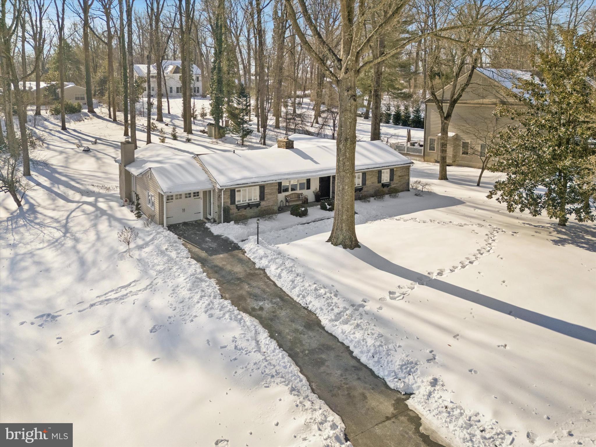 Welcome to 211 Deepdale Road in the highly desirable Deepdale neighborhood of Tredyffrin Township. This exceptional home offers approximately 2,550 square feet of thoughtfully designed living space on one level, four bedrooms, two full and one-half bathrooms, large brick rear patio, covered front porch. one-car garage with Tesla charger, and a gorgeous .68-acre private lot. The updated chef’s kitchen is sure to impress with Bosch appliances, hidden appliance cabinets, custom wine bar with beverage centers, under cabinet lighting, quartzite countertop, and center island with a sink, overhang seating for four, and a waterfall edge. The adjacent dining area has a wall of casements windows overlooking the back yard, custom built-ins, and a gas fireplace with a herringbone tile surround.  The family room is rich with character featuring exposed wooden beams, brick floor, gas fireplace with brick surround and custom wood mantle, and a four-panel slider drenching the room in sunlight.  The large primary bedroom includes a cedar lined walk-in closet, built-in cabinets, shoe storage, and a newer four panel slider to the rear patio.  The primary bathroom has a classic marble floor, spacious shower with bench seat and subway tiles, frameless glass enclosure, and an attractive single bowl vanity.  Three additional secondary bedrooms with ample closet space and a recently renovated hall bathroom round out this home. There are several smart home technologies such as Ring, Residio, Mysa, Schlage keyless lock, and ADT security system which can all be controlled via apps. Other features and improvements include hardwood floors throughout, clean/dry unfinished basement with tons of potential and storage, cedar lined double coat closet in the foyer, conveniently located laundry room, mudroom off the garage entrance with cabinetry and a custom bench with drawers, a half bathroom, new HVAC system and new hot water heater.  This property is conveniently located close to all major commuter routes, shopping, dining, and is walking distance to downtown Wayne, the Strafford Library, and the Septa Regional Rail.  Deepdale is a welcoming neighborhood with a civic association that coordinates several events throughout the year and is part of the top rated Tredyffrin-Easttown School District.  Don’t miss your chance to make this perfect property yours.