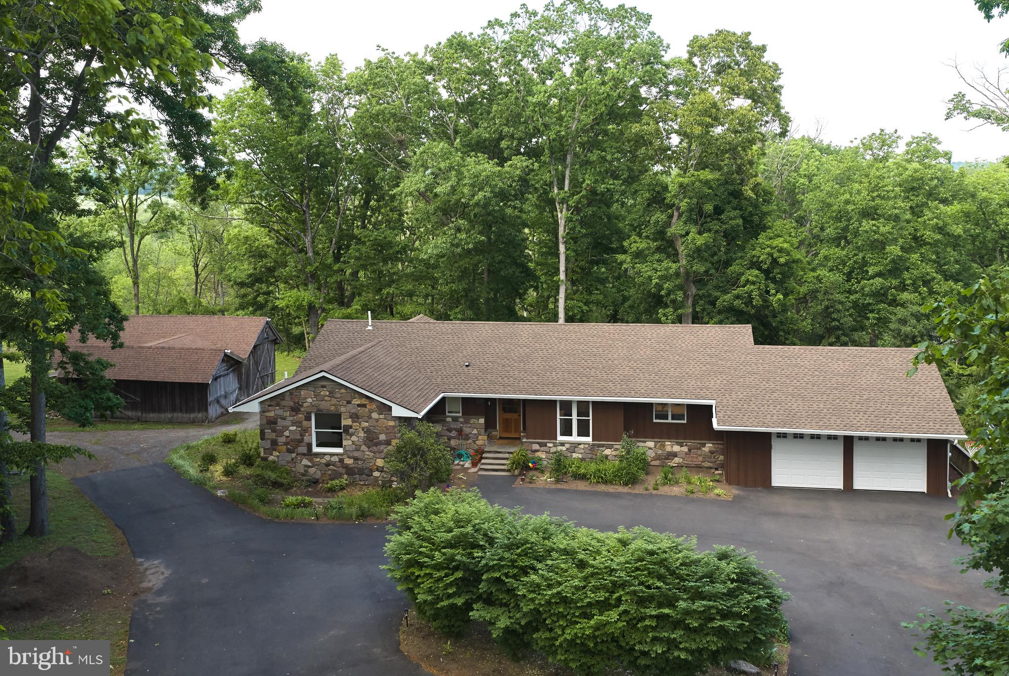 6683 Chapel Road offers the rare combination of a completely renovated home with the charm and setting of a classic Solebury rancher — all just minutes from downtown New Hope. Tucked along a quiet stretch of Chapel Road and surrounded by mature trees, this beautifully updated property delivers privacy, flexibility, and modern comfort in a serene natural setting.

Thoughtfully redesigned from top to bottom, the home features 3 bedrooms, 4 full bathrooms, a dedicated office, media room, full finished walkout lower level, and extensive upgrades throughout, including a new roof, soffits, gutters, TimberTech deck, updated HVAC and mechanical systems, upgraded electrical, recessed LED lighting, and new Anderson windows and doors throughout both levels of the home.

The main level is centered around a bright open-concept living, dining, and kitchen space designed for both everyday living and entertaining. Upon entering, the home unfolds into one expansive great room filled with oversized rear-facing windows that flood the space with natural light and frame peaceful backyard views. An original stone fireplace anchors the living space, blending timeless character with the home’s modern renovations. A welcoming entry nook adds warmth and functionality, while the seamless flow of the main living areas creates an airy and inviting atmosphere.

The beautifully renovated kitchen features custom Shiloh cherry cabinetry, luxury Jenn-Air built-in refrigeration, and upgraded appliances designed for both everyday living and elevated entertaining.

The primary suite serves as a peaceful retreat with tranquil backyard views, a beautifully updated bath featuring high-end Porcelanosa finishes, a double vanity, oversized shower, and abundant natural light, along with a generous walk-in closet complete with laundry hookups for optional main-level laundry convenience. A full hall bath with tub serves the additional main-level bedroom and office areas.

The fully finished walkout lower level offers exceptional versatility with 9+ foot ceilings, recessed lighting, and a full wall of sliding glass doors opening directly to the backyard. A spacious secondary living area anchored by a pellet stove creates an inviting extension of the home, while two additional bedrooms — including one with an ensuite bath — provide excellent flexibility for guests, extended family, or multigenerational living. The lower level bathrooms were fully renovated with high-quality Porcelanosa fittings and tile, custom shower enclosures, and thoughtful luxury finishes throughout. A dedicated media room with in-wall speaker wiring, oversized laundry room, and additional full bath further enhance the functionality of the space.

Outside, the property continues to impress with peaceful outdoor living spaces surrounded by mature landscaping and wooded views. A new TimberTech deck extends from the main level, offering the perfect setting for morning coffee or evening relaxation overlooking the private grounds. Set apart from the home, the detached barn sits beside a large flat grassy field perched atop a gentle bluff with seasonal long-range winter views through the trees — ideal for storage, workshop use, hobbies, or future possibilities. An attached two-car garage and expansive parking areas provide ample space for guests, recreational vehicles, or multiple-car households.

6683 Chapel Road is a rare opportunity to enjoy fully modernized living while still embracing the timeless character and peaceful setting that define Solebury Township.

Special Financing Incentives available on this property from SIRVA Mortgage. See documents for more information.