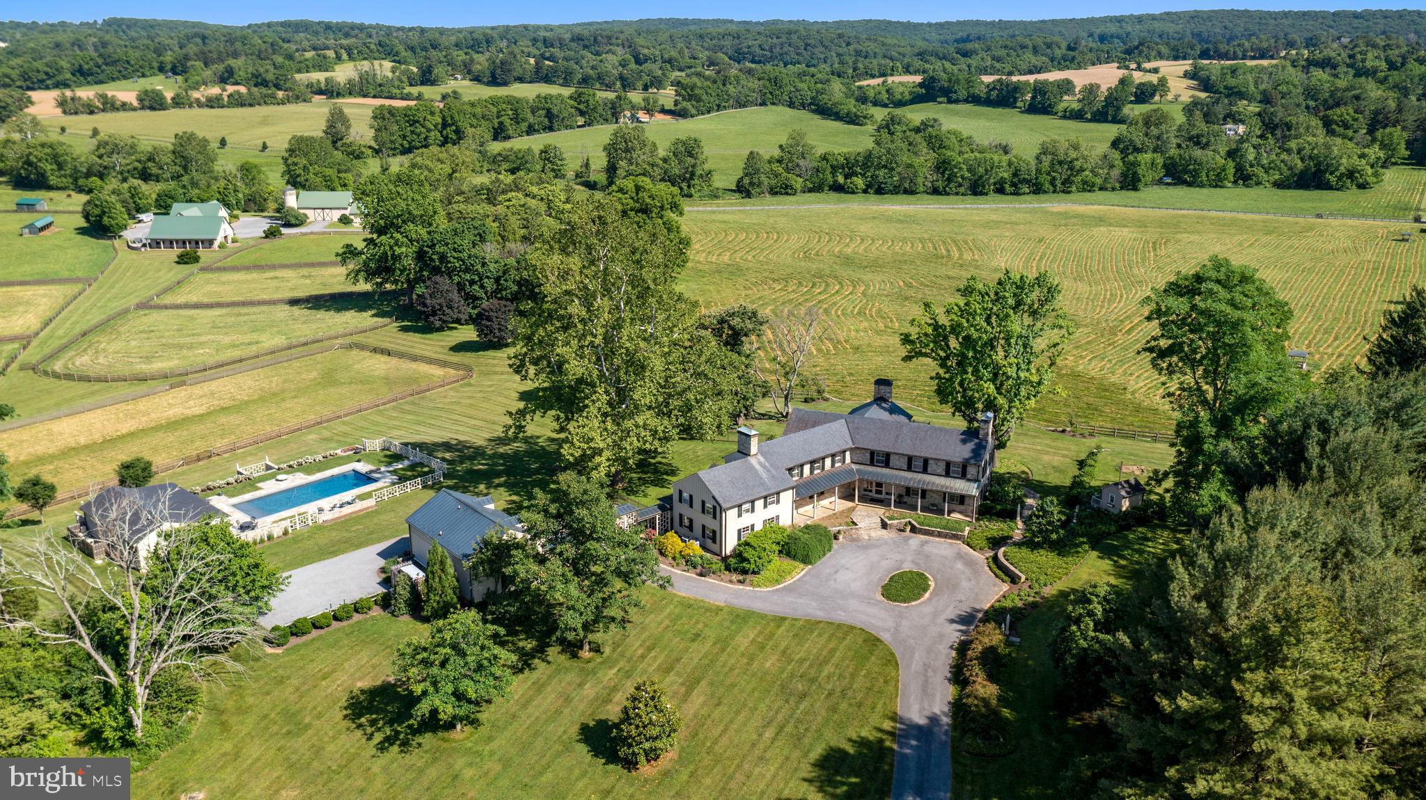 Iconic Goose Green Farm on one of Baltimore County's most bucolic and sought-after lanes, at the confluence of Mantua Mill Rd and Green Rd, this lovely Charles Nes designed stone 5+ BR estate farm is a once in a generation opportunity to own one of the finest, iconic equestrian farms in the region. Owning both banks of a long stretch of the Western Run with picturesque swimming holes and storybook picnic/fishing hide-aways, this 183 acre farm enjoys breathtaking, gently rolling land with literally miles of protected, open views and riding trails. Gorgeous gardens, magnificent old growth trees commanding spectacular views of sweeping meadows, fields, paddocks and incredible, best in class equestrian farm complex.  Bank Barn with silo observatory & 11 stalls, Stable with 5 stalls, 2nd Stable with 4 stalls. All with tack rooms & wash stalls. Amish built post & beam Tractor Shed/Workshop. Riding ring, 6 run-in sheds, many acres of fenced paddock, shooting clay facility. An 18th century stone Guest House, Garage Apartment and fabulous new Pool/ Pool House complex are just a few of the amenities on this beautiful maintained and impeccably updated fabled retreat.