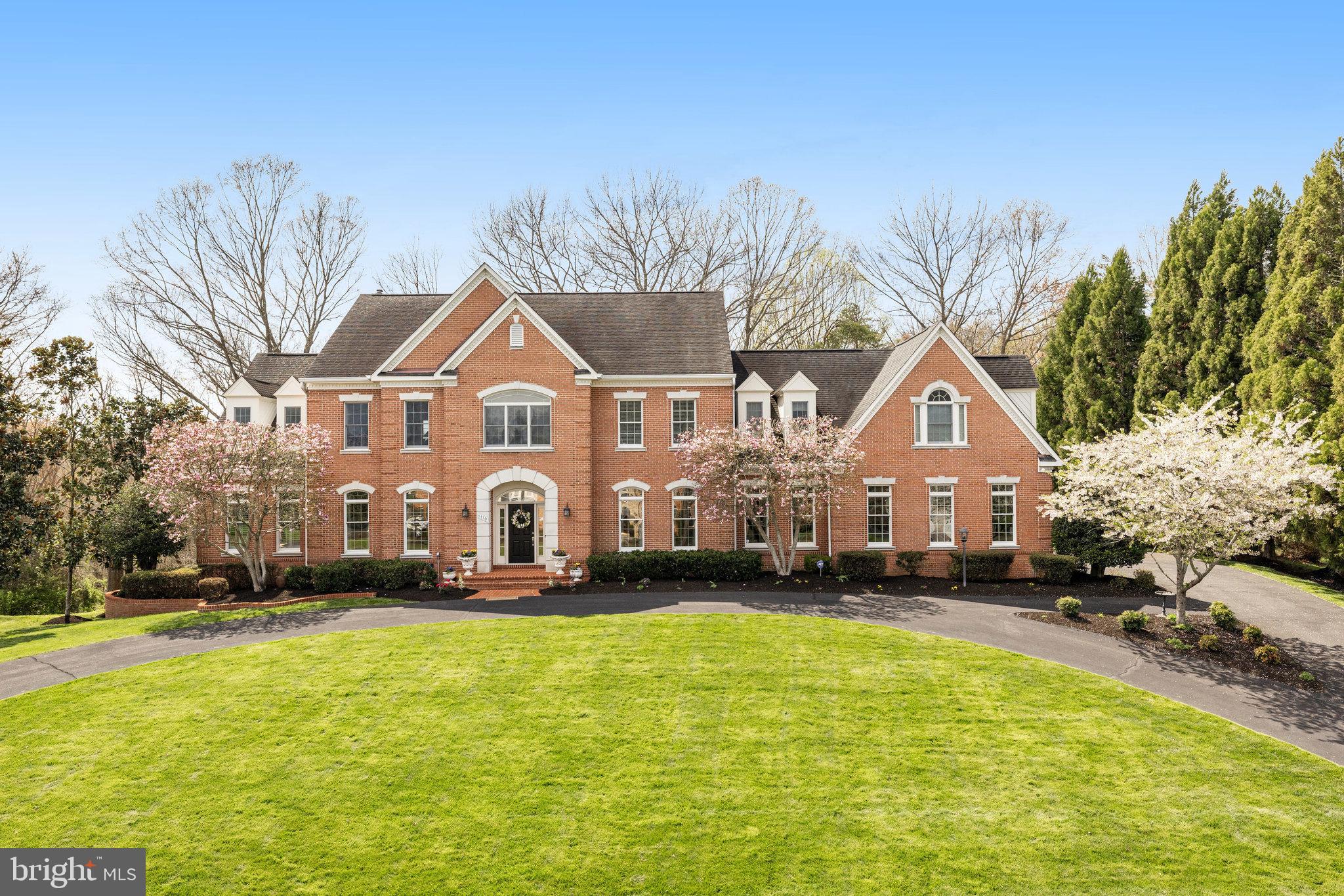 Welcome to this inviting brick home nestled in the charming Colvin Run Mill neighborhood.  This spacious 7,830 sq. ft. residence overlooks the scenic backdrop of Difficult Run Park.  A circular driveway welcomes you to a formal entrance, revealing an impressive two-story foyer with an elegant staircase, perfect for hosting gatherings in the formal dining, living room and sunroom spaces.  Flowing seamlessly, the floor plan connects these areas to the generous family room and kitchen.  Designed to be open and airy, the family room boasts a  impressive fireplace with marble surround and built-in cabinets.  Adjoining this area the breakfast area and gourmet kitchen, complete with a central island 5-burner gas cook top and top-of-the-line appliances.  A convenient catering kitchen, equipped with a second dishwasher, microwave, sink and full-size fridge, is just steps away.   Completing the main level are a private office and two powder rooms. 
Upstairs, the grand owner’s suite awaits, featuring a cozy sitting room with a fireplace, two spacious walk-in closets, and a luxurious bathroom with double vanity.  Additionally, there are four bedrooms, two with ensuite bathrooms and two sharing a buddy bathroom.
The walk-out lower level is dedicated to entertainment and relaxation, offering ample space indoors and outdoors for guests.  With an ensuite bedroom, library adorned with a fireplace and built-in bookshelves, and a recreation room leading to the expansive stone patio area through an atrium door., this level is ideal for leisurely pursuits.  This serene neighborhood includes direct access to the Difficult Run trail just across the street from this home.