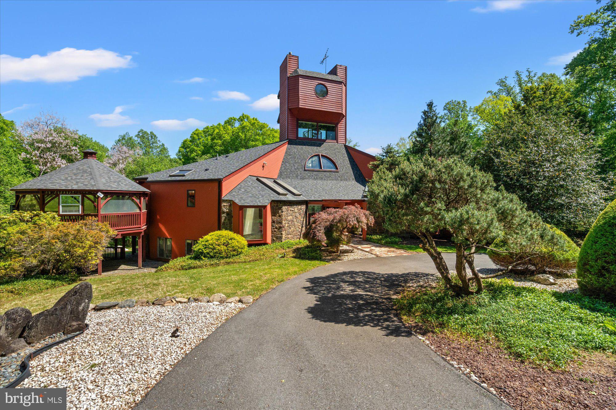 Set on nearly 7 acres in the coveted Mazza Woods enclave of Potomac, this extraordinary estate is a rare architectural offering designed by renowned modernist architect Roy Mason, celebrated for his distinctive use of glass, steel, and sculptural forms that blur the boundary between structure and landscape. Built in 1982 and offered for the first time, this one-of-a-kind residence spans approximately 6700 square feet and stands as a true work of art.
A long, private driveway winds through the trees, leading you to this quiet retreat. For those who wish to explore, the property unfolds into acres of forest, with a peaceful creek nestled at the base of the hillside, offering a natural sanctuary just steps from your door. The outdoor setting feels like an expansive private park, magically transforming with the changing seasons.
Inside, walls of glass frame panoramic views in every direction, flooding the home with natural light and creating a seamless connection to the lush, private surroundings. Soaring ceilings and an open floor plan on both levels make this an entertainer’s dream, while a dramatic three-story staircase leads to a breathtaking observation tower—an architectural centerpiece offering unmatched vantage points over the property.
Designed for both grand entertaining and intimate retreat, the home features 4 bedrooms and 3.5 baths, including a serene primary suite with its own sleeping porch—perfect for quiet mornings immersed in nature. The main level offers multiple seating and dining areas adorned with Murano light pendants, while the kitchen is equipped with granite countertops and high-end appliances. The lower level includes two additional bedrooms with a shared bath, plus an ensuite bedroom, and opens to a tranquil Zen garden, creating a peaceful sanctuary.
Outdoors, the property transforms into a private resort. A stunning in-ground pool anchors the grounds, surrounded by mature landscaping and specimen trees. The setting is alive with wildlife, including great blue herons, woodpeckers, blue jays, sandpipers, bald eagles, ospreys, and red-tailed hawks. Just a quarter mile from the C&O Canal towpath and the Potomac River, the location is both idyllic and inspiring.
Despite its secluded, oasis-like feel, this remarkable property is just minutes from Potomac Village shops and restaurants, with easy access to downtown Washington, D.C. Additional features include steel-frame construction and a two-car attached garage and new roof.
A truly special home that is architecturally striking, surrounded by nature, and perfectly suited for a lifestyle of beauty, privacy, and easy, relaxed entertaining.