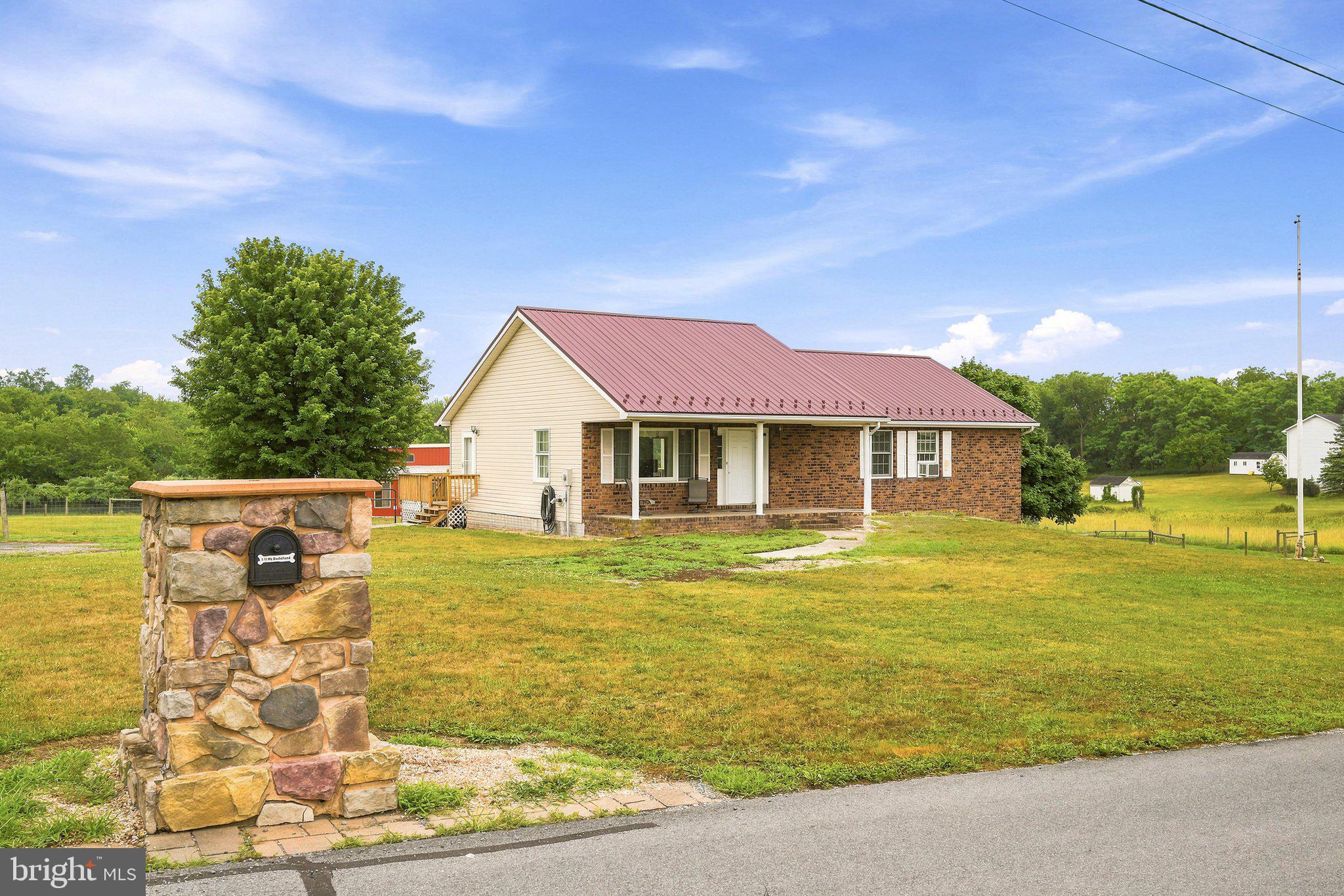 What an incredible property with so much to offer, located in the highly sought-after Red Hawk community! While there is an HOA, it has very few restrictions, giving you the flexibility to truly enjoy your property. If you've always wanted to raise a steer or have a small hobby farm, you can do that here.

The standout feature is the impressive 48' x 52' barn/workshop—exactly what so many buyers are searching for. This 2,000-square-foot building features a durable metal roof with gutters, block construction, and a poured concrete floor. It's fully equipped with plenty of electrical outlets, including four 220-volt outlets, plus a built-in motorcycle lift. Originally designed with four horse stalls, two remain while the other two have been opened up for additional workspace. The barn also includes two frost-free water hydrants, skylights, industrial fans, and two large sliding doors that allow you to drive straight through. It's truly a must-see.

The all-brick ranch home offers three bedrooms and two bathrooms with the convenience of one-level living. Inside, you'll love the bright, welcoming atmosphere and abundance of natural light. The kitchen, mudroom, and bathrooms feature tile flooring, while beautiful oak hardwood floors run throughout the rest of the home.

The spacious kitchen offers plenty of cabinet storage, a center island with a cooktop, and a wall oven, making it perfect for everyday living and entertaining. Just off the kitchen, the mudroom includes the laundry area for added convenience. The adjoining dining room opens to a beautiful stone patio overlooking the peaceful backyard, creating the perfect place to relax or entertain.

The home is heated with both a pellet stove and electric baseboard heat. A newer metal roof, combined with exceptional insulation, helps keep energy costs surprisingly low. Although there is currently no HVAC system, the home already has a return air supply in place and is ready for ductwork and an outdoor unit if central air is desired.

The unfinished basement offers endless possibilities for future living space, storage, or a workshop.

Outside, you'll find even more to love, including a large fenced garden, approximately one acre already fenced for a horse or cow, an additional frost-free water hydrant, and a concrete pad that's perfect for a picnic table or outdoor gathering area.

This is a rare opportunity to own a versatile property that offers space, functionality, and country living with the benefits of a desirable neighborhood. Schedule your private showing today—you'll want to see everything this amazing property has to offer!