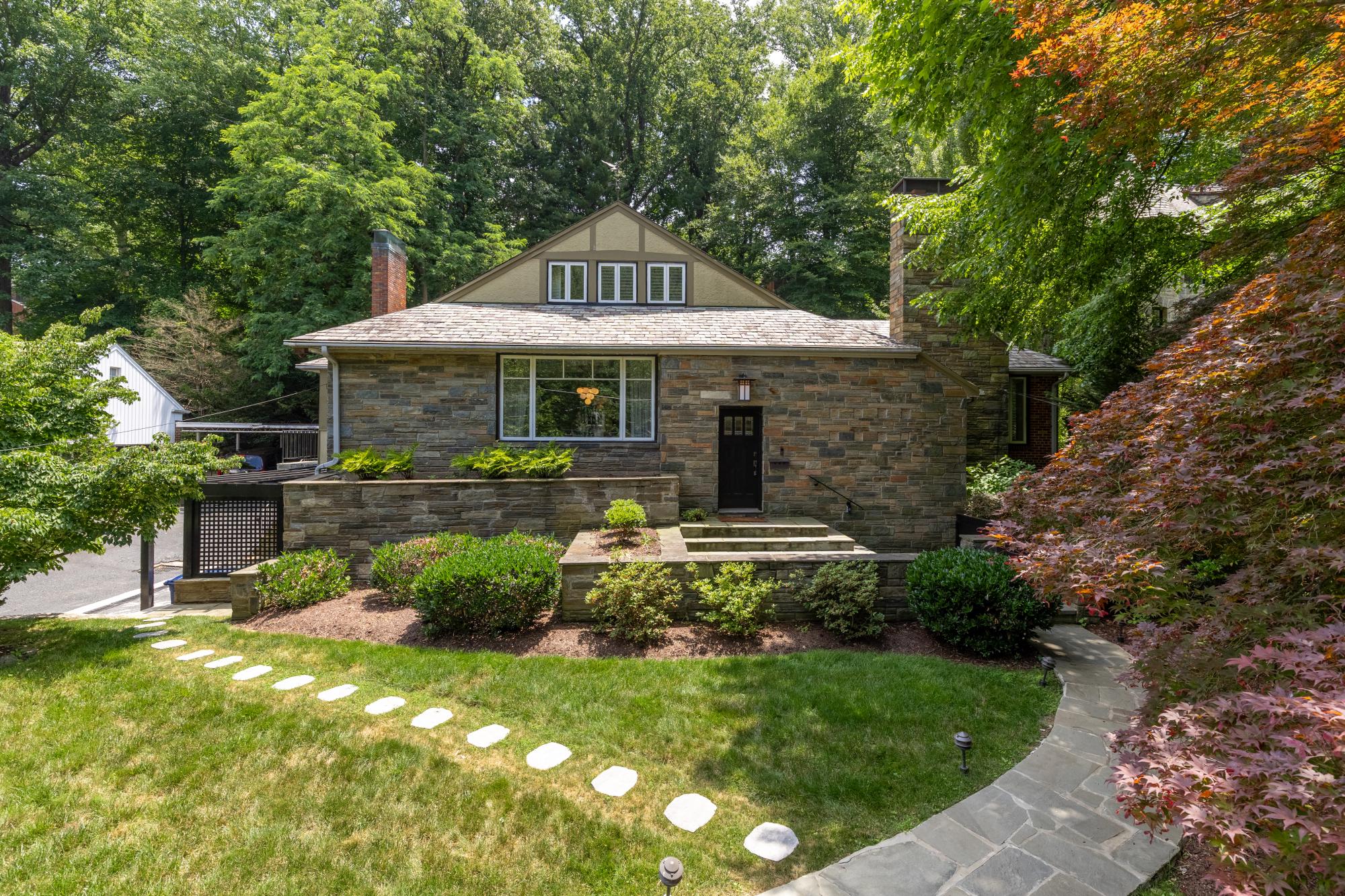 A rare offering in the heart of Crestwood, 4335 Blagden Avenue NW is a distinguished residence where architectural character, thoughtful updates, and effortless livability converge. Set on an expansive 0.34-acre lot surrounded by mature trees and lush landscaping, this timeless home offers over 4,000 square feet of beautifully finished living space, including five bedrooms and three-and-a-half baths.

From the moment you enter, natural light and thoughtful flow set the tone. Large windows, elevated lighting, and hardwood floors throughout create warmth and continuity, while the gracious floor plan offers an ideal balance of formal elegance and everyday comfort. The main level is both refined and functional. A welcoming foyer introduces the home, where a thoughtfully designed coat closet/mudroom and discreet powder room provide everyday ease.

Opposite, the formal dining room overlooks the front yard, creating a lovely backdrop for entertaining and daily meals alike. From there, the floor plan unfolds into a warm living room anchored by a fireplace and framed by large windows with plantation shutters, complemented by a handsome study with custom built-ins and a cozy sunroom that opens to the back deck.

Privately positioned on this level, the spacious primary suite offers the ease of main-level living. The bedroom features a walk-in closet with custom shelving and a beautifully renovated ensuite bath complete with a walk-in shower, double vanity, and heated floors. The bedroom also features an atrium glass door that leads to the back patio where you can enjoy your morning coffee or relax in the hot tub. Just down the hall is a generous second bedroom for guests, family, or an additional home office.

The light-filled kitchen features large windows, granite counters, a Bosch gas range, built-in microwave drawer, and ample cabinet storage, along with access to the driveway and backyard through a second mudroom.

Upstairs, two additional bedrooms share a well-appointed full bath, offering comfort and privacy for family or guests. This level also features generous storage, including a large cedar closet—ideal for storing holiday décor and seasonal items.

One of the home's most distinctive features is its exceptional indoor-outdoor connection. Multiple living spaces open seamlessly to the deck, patio, hot tub, outdoor fireplace and beautifully landscaped yard, creating a resort-like atmosphere that is ideal for both everyday living and entertaining. The backyard is fully fenced for privacy and enhanced by an irrigation system for the yard, along with outdoor lighting in both the front and rear.The floor plan lives comfortably and offers a unique sense of retreat while remaining highly functional for modern living. 

The lower level expands the living space even further with a substantial recreation room featuring its own fireplace, a dedicated wine cellar and wine fridge, and abundant flexibility for media, fitness, or play. There is also a fully equipped in-law suite with a full kitchen, full bath, bonus room, and separate entrance that provides ideal accommodations for guests, an au pair, or extended family. There is also a large laundry room on this level. Additional highlights include an attached garage with an electric vehicle charger, ample storage for sporting and outdoor equipment, and entrance through the lower level. In addition to the garage, there is a covered carport and generously sized shared driveway, which provides ample space for guests and allows vehicles to enter and exit with ease, so parking is never a concern.

Located in sought-after Crestwood—moments from Rock Creek Park and convenient to 16th Street, downtown DC, and neighborhood favorites in Cleveland Park and Adams Morgan—this property offers a rare combination of serenity, space, and accessibility.

4335 Blagden Avenue NW is a home of substance and story—an uncommon opportunity to own a truly special residence in Northwest DC.