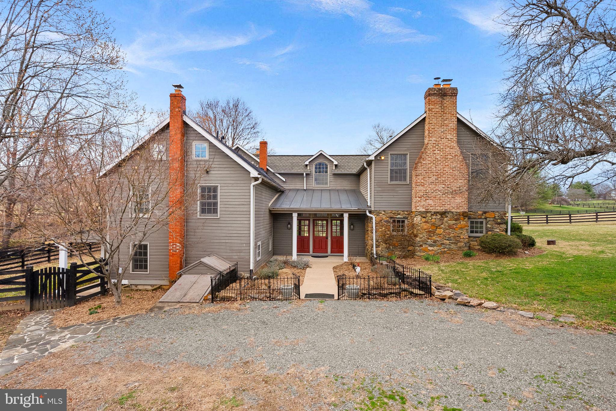 Finding the perfect home is exciting—but beginning your next chapter in a historic property is a rare opportunity. Located just outside the historic village of Waterford, this exceptional home is part of an  equestrian community of only 22 residences, offering access to 120 acres of private riding and nature trails.  Priced $70,000 below recent appraisal. 
Originally built in 1880, this one-of-a-kind property sits on 5.63 private acres and beautifully blends historic character with thoughtfully designed additions that provide modern comfort. The home is rich with charm, featuring hand-hewn beams, three fireplaces, and picturesque stone walkways throughout the property.
A grand entry foyer with slate flooring welcomes you inside, where French doors open to a patio and the serene rear yard. The stunning chef’s kitchen features custom cabinetry, upgraded countertops, a large center island, and a high-end Viking stainless steel range—perfect for cooking and gathering. The kitchen flows seamlessly into a bright eat-in area with a bowed window and an inviting family room highlighted by a stone fireplace with wood-stove insert.
The elegant primary suite offers cathedral ceilings, hardwood floors, a cozy fireplace, and two spacious walk-in closets. The luxurious primary bath includes dual vanities, an upgraded shower, and a relaxing soaking tub.
This home also provides several private spaces ideal for home offices, all supported by high-speed Xfinity internet. The walk-out lower level adds even more character, featuring a charming pub-style entertaining area with exposed stone walls, wood-stove insert, and a kitchenette complete with sink, refrigerator, and dishwasher—perfect for gatherings or quiet evenings. Large windows fill the lower level with natural light.
Outdoor living is equally impressive. The updated barn includes a finished upper-level gathering space ideal for events, while the main level offers flexible use for animals, vehicles, or hobbies. Additional features include a chicken coop, run-in shed, and fenced paddock areas. A beautiful stone patio provides the perfect setting for outdoor entertaining and enjoying the peaceful surroundings.
Residents of this intimate community enjoy access to 120 acres of shared open space with riding trails, making it ideal for horse enthusiasts, nature lovers, and hikers alike.
This is a rare chance to own a truly historic home in an exceptional setting—where charm, privacy, and lifestyle come together.