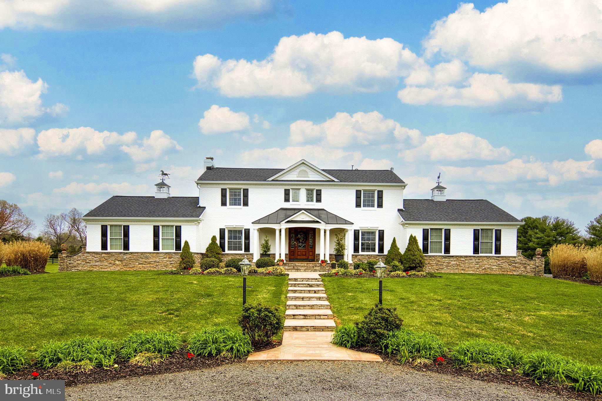 This fully custom home and property offers numerous beautiful details that must be experienced in person to appreciate. Situated minutes from Haymarket, this 15-acre farm ready for horses or other animals, provides a tranquil escape with easy access to incredible amenities within a 5 minute drive to Haymarket. The recently painted home features an elegant white exterior, black roof, and a blend of brick, James Hardie board, and stone water table.

 Upon entering, you'll be impressed by the stunning curved staircase and architecture. The 900 SF main level owner's suite includes a fireplace, walk-in closet, and luxurious bathroom with a soaking tub and custom vanities. The kitchen boasts custom Wood Mode knotty cherry cabinetry, high-end appliances, a 10' island, and views of Bull Run Mountain. The family room offers cathedral ceilings, authentic hand-scraped walnut flooring, a two-sided fireplace, and striking mahogany glass doors with faux wrought iron inserts. The upper-level features four bedrooms and two bathrooms, including an en-suite, while the lower level includes versatile spaces like an Airbnb rental apartment and a 900 SF art studio/exercise room. 

The property boasts a six-stall barn with a heated tack room, bathroom, wash rack, 5 fenced pastures, and beautiful Magnolia trees. A second barn in the rear provides additional stall space and storage. Please note that the house septic system is a 4-BR conventional perc and per country rules can accommodate up to 8 people.  The barn has its own 3-BR conventional septic field.  With endless possibilities for creative uses such as a family subdivision, business venture, or event hosting (subject to county permitting), this property is must-see. Schedule an appointment today to explore this fabulous property!