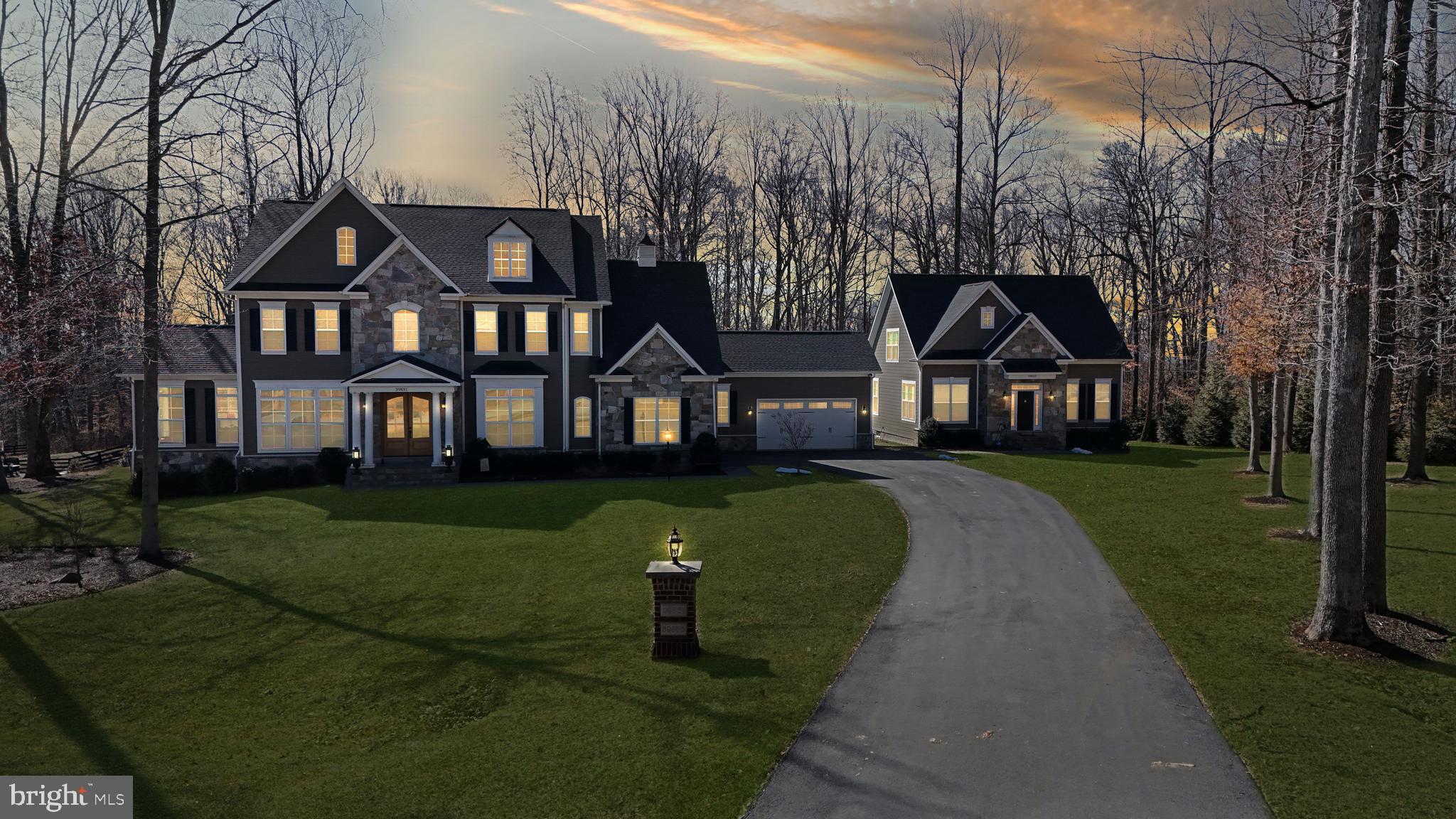 **Catered Open House Saturday, March 22nd from 3-5pm and Sunday, March 23rd from 3-5pm**This stunning Carrington-built estate is a rare and extraordinary find, offering a tranquil setting, a premium lot, and a wealth of luxurious upgrades. Located just outside Historic Downtown Leesburg, this home provides easy access to the Dulles Greenway, Leesburg Outlets, Dulles Airport, and Virginia’s renowned wineries. The main house is an architectural masterpiece, designed with both elegance and functionality in mind. The main level boasts an expansive 20-foot-wide chef’s kitchen, complete with quartz countertops, a Viking double oven, a Viking six burner cooktop, a Bosch dishwasher, an oversized and storage friendly island, and custom pull-out shelving—making it a dream for cooking, baking, and entertaining. Throughout the main level, distressed hickory engineered hardwood flooring adds warmth and sophistication, complementing the home’s refined aesthetic. The great room is an absolute showstopper, featuring a coffered ceiling, black slate framed gas fireplace, and floor-to-ceiling windows that flood the home with natural light. The inviting Keeping room and Club room, both with vaulted, beamed ceilings, add character and warmth. These rooms offer breathtaking sunrises and nighttime blinking city-light views creating spaces that feel both cozy and grand, while creating a truly mesmerizing ambiance. Additionally, a fully ADA-compliant main level living area offers a private bedroom with a walk-in closet, a full bath, a sitting room/office, and its own enclosed washer, dryer, and basin sink ensuring comfort and accessibility. Upstairs, the home offers four spacious bedrooms, each with its own private bath. The primary suite stands out as a true retreat, featuring a classically styled freestanding tub that adds a touch of luxury. A dedicated laundry room with basin sink adds convenience and functionality. The lower level is an entertainer’s dream, featuring a bedroom with a full bath, a recreational room with a wet bar and sophisticated cabinetry, an exercise room, a half bath, and extensive storage spaces. This home was designed with multi-generational living in mind. Whether you have extended family under one roof, frequent visitors, or simply need flexible living spaces, the layout offers both connection and privacy. The fully equipped Carriage home is a game-changer. The main level features a large bedroom with abundant closet space and full bath. Additionally, a well-apportioned modern kitchen with breakfast nook, a laundry area, a sizable pantry and a spacious living room adds to the uniqueness of this house. The upper level includes an expansive Primary bedroom and full bath, while the lower level provides a recreational room, a den, a full bath, and ample storage. Step outside to enjoy a charming private patio, perfect for outdoor relaxation. This home is ideal for independent living while staying close to loved ones. The exterior of the estate is just as impressive as the interior. A large Trex deck overlooks a meticulously landscaped yard, designed by Rivers Edge, featuring custom hardscaping, an irrigation system, and 41 newly planted mature trees. The property also includes plans for a 40’ x 20’ pool, offering the ability to create a private backyard retreat. A multifunctional shed with lighting and electrical is perfect for the home hobbyist and gardener. The home’s extensive Stone and Hardie Plank siding ensures lasting beauty. For those who appreciate convenience, the estate includes two separate two-car garages, providing plenty of space for vehicles and storage. Tying it all together, a pineapple-weather vane and cupola crowns the home—a timeless symbol of warmth, hospitality, and charm, making this estate as inviting as it is impressive. Every inch of this meticulously designed multi-generational estate showcases unparalleled craftsmanship, luxurious finishes, and thoughtful upgrades.