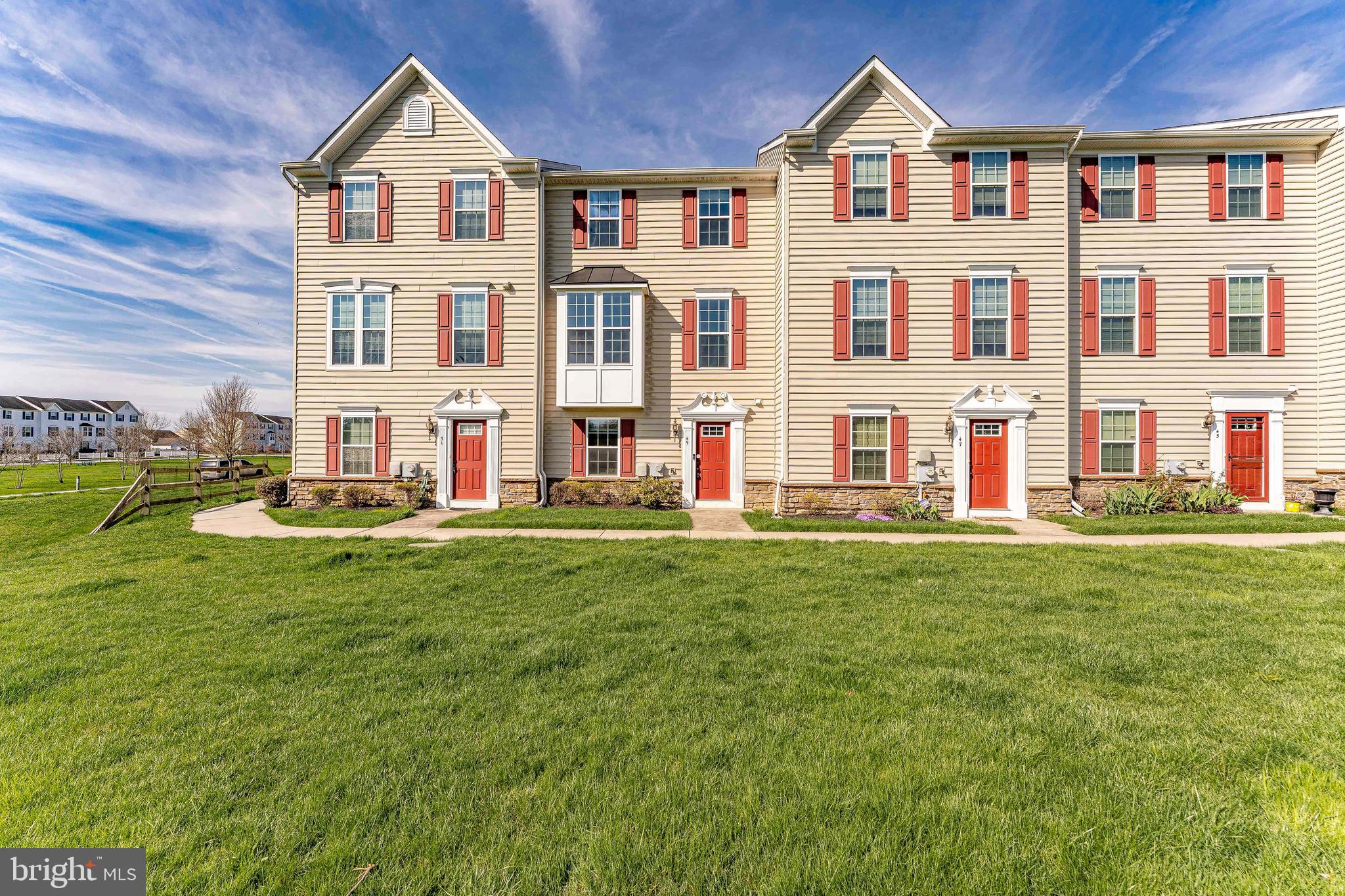 Welcome to 49 Maffet Lane, a 3-bedroom, 2.5-bath townhouse in the Sadsbury Park community of Coatesville. This home offers a two-car garage and a two-car driveway for convenient parking. Entering on the lower level, a short set of steps leads to the main living area. The kitchen features hardwood floors, granite countertops, a center island with seating, stainless steel appliances, and a pantry closet. A peninsula with an overhang opens to the living room, creating a connected and functional layout. The kitchen flows into the dining area, which includes a chandelier and access to the composite deck. The living room offers hardwood floors, crown molding, built-in speakers, a double window with a cozy alcove, and access to the second level. Upstairs, a convenient laundry closet includes a front-load washer and dryer. The primary bedroom features carpet flooring, a tray ceiling with crown molding, a chandelier, and a walk-in closet. The en-suite bathroom includes tile flooring, a step-in shower with dual shower heads, and a double sink vanity. Two additional bedrooms provide flexible space for family, guests, or a home office. A full hall bathroom with a tub and shower combination completes this level. The lower level includes a family room with hardwood floors, crown molding, a walk-in closet, a utility closet, and access to both the front entry and garage. A powder room with a pedestal sink is also located on this level. Residents of Sadsbury Park enjoy community amenities including a pool, playground, dog park, walking paths, and open green space, with HOA coverage for common area and lawn maintenance. Conveniently located near local shopping, grocery stores, restaurants, and more, this home offers both comfort and convenience. Don’t miss the opportunity to make 49 Maffet Lane your new home.