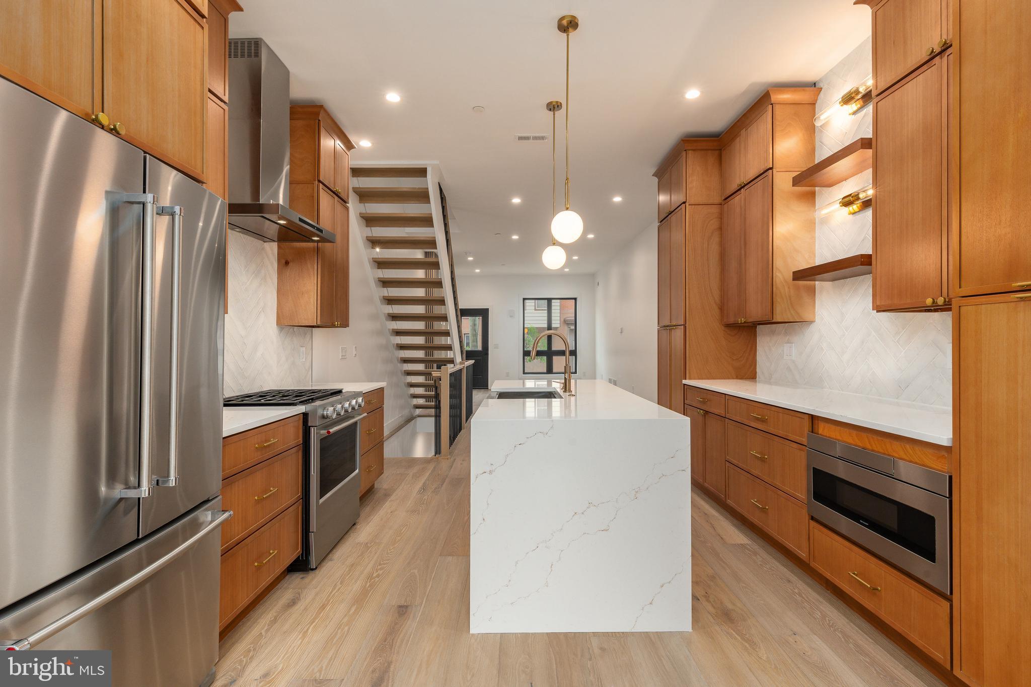 Stunning new construction in one of Philadelphia’s most desirable neighborhoods, offering the perfect blend of modern design, luxury finishes, and everyday convenience. This newly completed 4-bedroom, 3.5-bath residence showcases a bright, open-concept layout with 10-foot ceilings, wide-plank white oak flooring, and a striking architectural staircase that sets the tone from the moment you enter. The main living space is anchored by a sleek fireplace feature wall and flows seamlessly into a designer kitchen complete with floor-to-ceiling cabinetry, quartz waterfall island with seating, premium KitchenAid appliance package, and elegant finishes throughout. Thoughtfully designed for both entertaining and comfort, the home includes a convenient first-floor powder room and refined details such as champagne bronze fixtures and custom tilework.

The upper level offers a luxurious primary suite retreat featuring a wet bar with beverage center, spa-inspired bathroom with freestanding soaking tub, dual vanity, and oversized walk-in shower. Additional bedrooms are generously sized with modern design touches, while the fully finished lower level expands your living space with a second family room, bedroom, full bath, and abundant natural light. Enjoy multiple outdoor living areas including a private rear patio and an expansive rooftop deck with panoramic Center City skyline views. Located just minutes from top neighborhood destinations like Loco Pez, Cedar Point Kitchen, Reanimator Coffee, Suraya, Laser Wolf, and Pizzeria Beddia, along with nearby cafés, gyms, and parks such as Penn Treaty Park. Easy access to SEPTA, I-95, and major commuter routes ensures seamless connectivity across the city and beyond. A rare opportunity paired with a 10-year tax abatement—this is elevated city living at its finest.