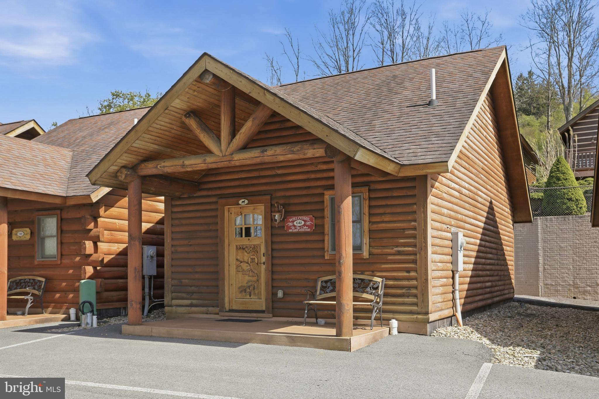 BOAT SLIPS! LAKE ACCESS & VIEWS! 4TH OF JULY FIREWORKS VIEWS! SKI SLOPE VIEWS!  Cabin #42 at The Lodges of Sunset Village is a detached unit with a king bed, a full bath, and it's fully furnished and turnkey. This unit has a porch, a patio, and a hot tub, too! 

14.56% GROSS REVENUE YIELD with a PROVEN  RENTAL HISTORY GENERATING AN AVERAGE OF $47,317 IN ANNUAL GROSS RENTAL INCOME over the last FIVE YEARS with an AVERAGE of 142 DAYS RENTED annually for an ADR of $333.

Rich in mountain character and charm, this log cabin features uniquely carved wooden doors, beautiful beamed ceilings, warm wood walls, and inviting spaces that create an authentic lake-and-mountain retreat feel. Additional features include lake and ski slope views, expansive decks, upgraded finishes, open-concept living, a stacked-stone gas fireplace. Enjoy incredible views of Deep Creek Lake and Wisp, along with front row seats for seasonal beauty and memorable moments, including views of the annual July 4th fireworks. 

This is an exciting opportunity for
buyers seeking both personal enjoyment and investment potential. Experience one of Deep Creek Lake’s
newest ownership opportunities at The Lodges at Sunset Village. Community amenities include lake access with 10 shared dock slips and an
impressive 1,320 square foot waterfront dock area perfect for fishing, swimming, launching kayaks,
relaxing by the water, and enjoying summer fun at the lake. Residents and guests also enjoy a lakeside
gazebo, playground, fire pit, gathering areas, pet-friendly accommodations, abundant parking, and on-site
professional management. The monthly condo fee provides exceptional convenience, including most
utilities, snow removal, trash service, and yard maintenance, for a low-maintenance ownership experience. Whether you're searching for a vacation retreat, income-producing investment, or both, The Lodges at
Sunset Village offers a rare opportunity to own at Deep Creek Lake. Call today for your private showing!