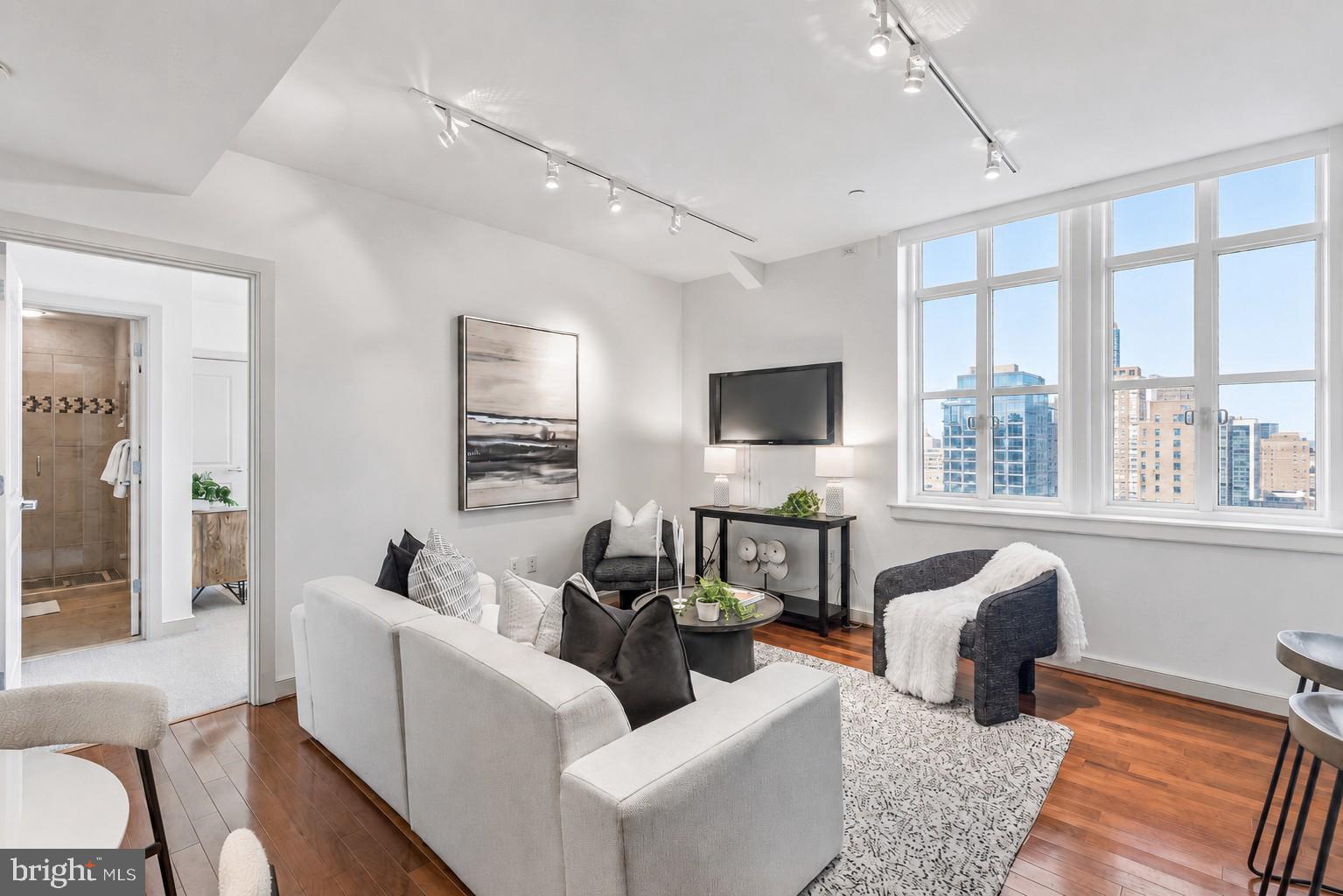 Set high above Center City with sweeping skyline views, this beautifully appointed two bedroom, two bath residence offers an elevated living experience at the Packard Grande. The gracious living and dining areas are defined by soaring nine foot ceilings, rich hardwood flooring, and expansive windows that fill the home with beautiful natural light. The well-appointed kitchen features a breakfast bar, shaker-style cabinetry, stainless steel appliances, and rich granite countertops, creating an elegant yet functional space for everyday living and entertaining. Both bedrooms are generously proportioned and offer excellent closet space. The updated bathrooms feature a polished, spa-inspired design with ceramic tile flooring, stone counters, ceramic sinks with storage vanities, designer shower fixtures, and tasteful upgraded finishes. Additional enhancements include custom closet systems, motorized window shades in each room, designer lighting, and thoughtful details throughout, creating a residence that feels refined, comfortable, and move-in ready. Residents of the Packard Grande enjoy the convenience of a 24-hour concierge, an impressive rooftop deck with stunning city views, and an on-site fitness center. Valet parking is available next door in a public garage for an additional fee. Ideally situated in the Rittenhouse and Avenue of the Arts corridor, this residence offers immediate access to acclaimed dining, premier shopping, renowned cultural destinations, vibrant nightlife, UPenn and Drexel campuses, HUP and CHOP, and major public transit lines.