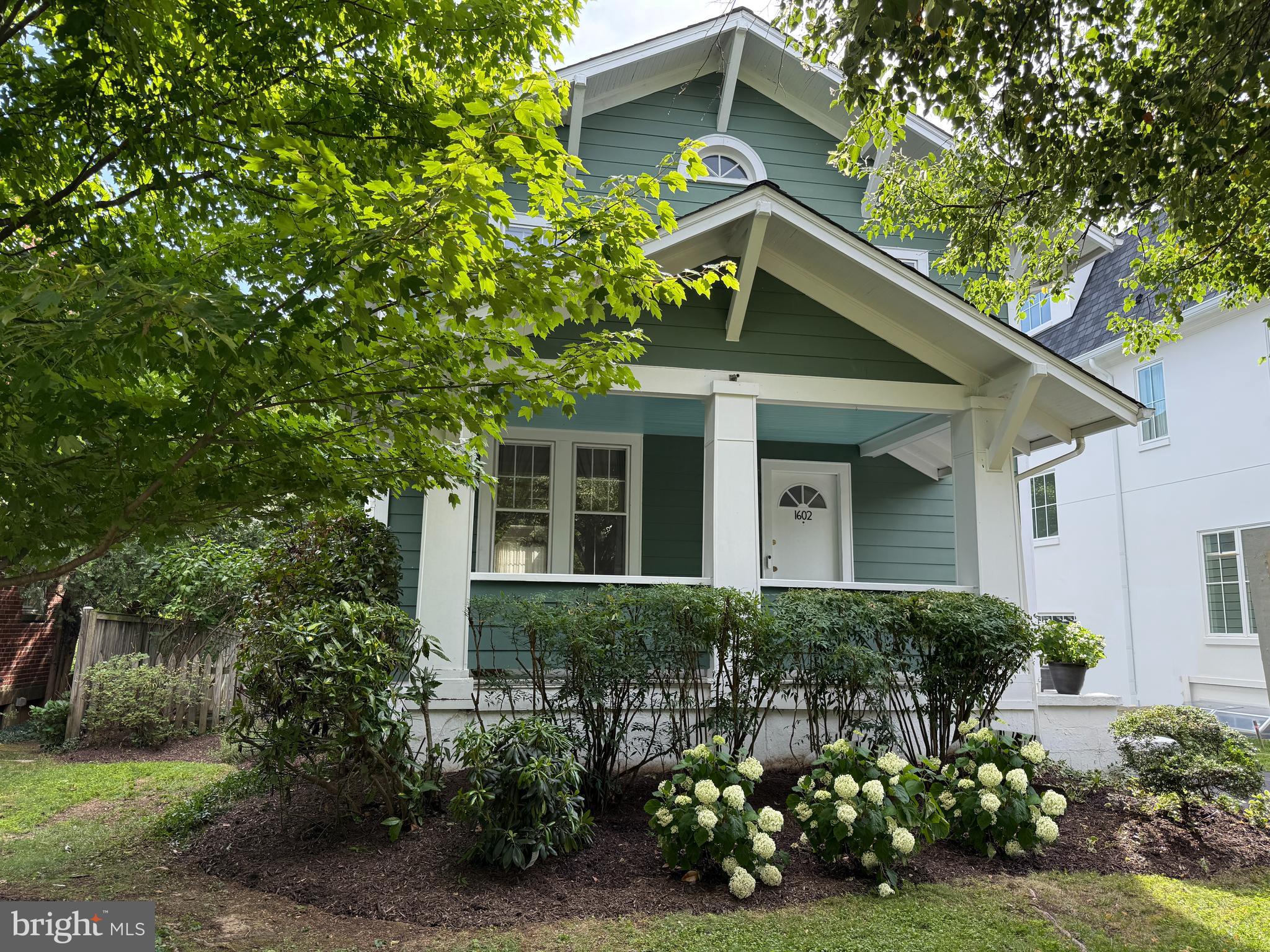 Nestled on a picturesque tree-lined street in sought-after Lyon Village, just two blocks from the vibrant heart of Clarendon, this charming 1920s farmhouse seamlessly blends timeless character with everyday comfort. An expansive front porch welcomes you home, leading to a gracious foyer highlighted by a beautiful original staircase and soaring 9-foot ceilings.

Rich oak floors flow throughout the main level, where a formal living room with a cozy fireplace and an oversized dining room create inviting spaces for entertaining. The open-concept kitchen, complete with a sunny breakfast area, overlooks the family room, offering the perfect gathering place for family and friends.

Upstairs, heart pine floors add warmth and character to a generous primary ensuite, three additional bedrooms and a full bath, and a convenient office nook ideal for working or studying from home.

The finished lower level provides flexible living space with a recreation room, children's play area, and laundry room. Outside, enjoy a fenced backyard with plenty of room to play, garden, or relax, along with an oversized garage offering exceptional storage and convenience.

Combining classic farmhouse charm, generous living spaces, and an unbeatable Lyon Village location, this special home offers the very best of Arlington living with parks, dining, shops, gyms and Metro at a stones throw.