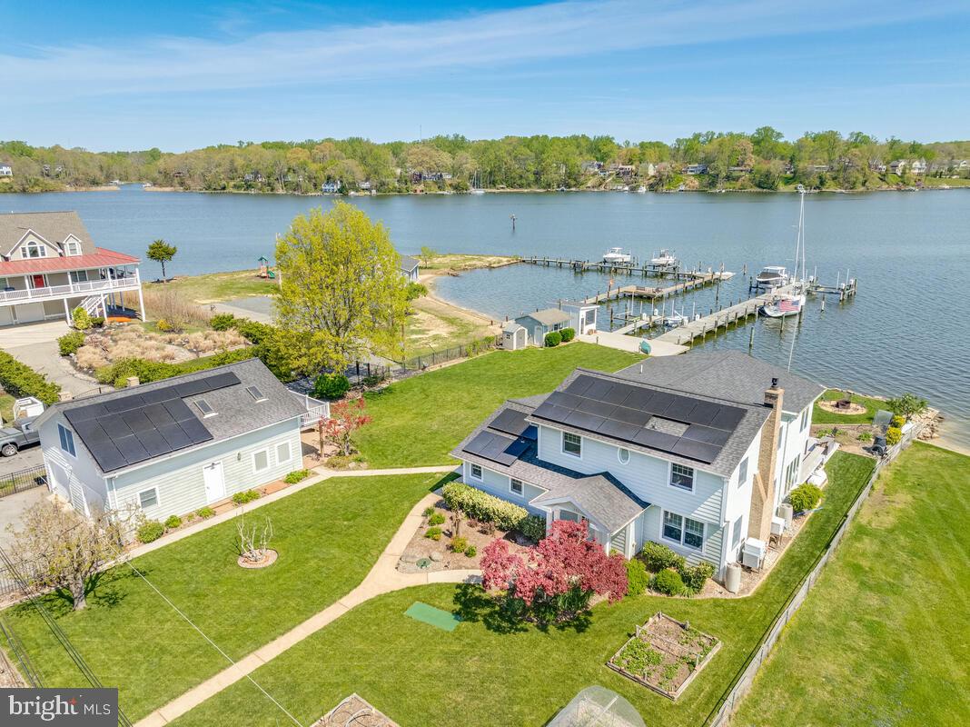 Breathtaking views from every room! This property's unique location on the South River allows for both stunning sunrises and  awe-inspiring sunsets. The main house features 4 bedrooms and 3 full baths. The guest house offers a 5th bedroom and 1.5 baths .  In the main house, a beautiful sunroom spans the entire rear of the house with walls of windows that allows for plenty of natural light and peaceful water views.  The gourmet kitchen with a separate prep area, breakfast bar and gas cooktop is perfect for the chef in anyone! A separate dining room just off of the sun room is a great place for year round entertaining letting the outdoors in. Extensive water views and walls of windows highlight the primary suite with sitting area and spa like primary bath with soaking tub, separate walk-in shower and walk-in closet, The guest apartment features a bedroom, full bath, kitchenette, great room, bamboo flooring and water side balcony. On the main level of the guest house is an office with stone tile flooring, kitchenette, built-in cabinets, half bath , walls of windows and a paver patio to take in the view!  The detached 2-car garage offers 2 openers and workshop area with 3 work benches and extensive shelving. This is the perfect opportunity for the garden lover in you with raised beds and a lawn sprinkler system for lawn irrigation and the watering of all of the beds. The 170' pier is 10' wide and features water, electric, 6 slips, 3 electric lifts and a water depth of 10'+.  A screened gazebo sits just off the 51'x17' shore deck by the water's edge and storage shed to store all of your outdoor needs. The 36'x4' finger pier is an added bonus! Enjoy your morning coffee or an evening of relaxation on the multi-level decking off of the sunroom overlooking the 120' of waterfrontage.  This once in a lifetime waterfront opportunity offers everything you could possibly want.