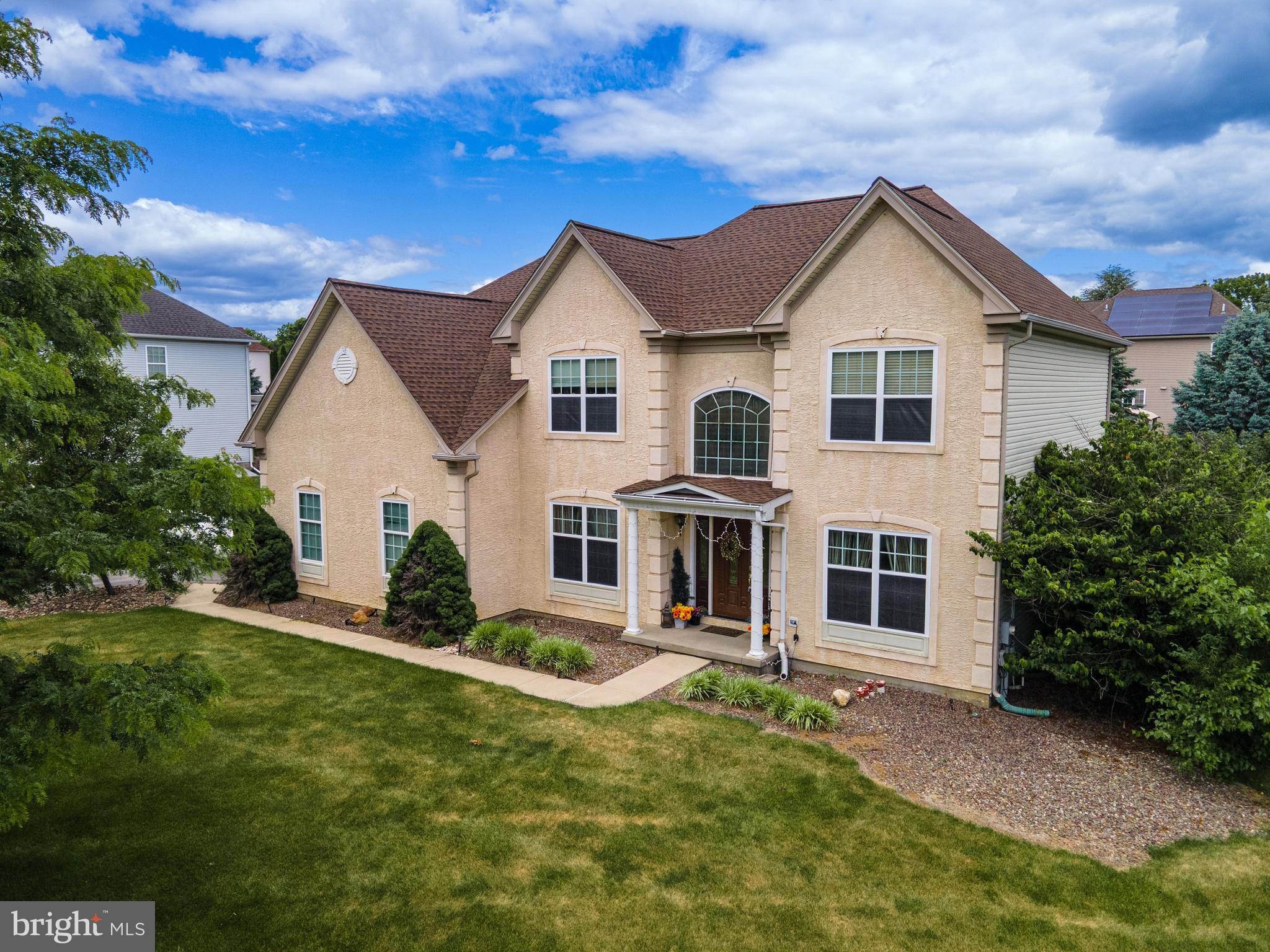 Welcome to this beautifully appointed 4-bedroom, 2.5-bath stucco Colonial featuring a charming covered entryway and built-in speakers throughout. *BRAND NEW ROOF & CARPETING PLUS UPGRADED APPLIANCES!* Step inside to a grand 2-story central hall foyer adorned with baseboard and crown molding, setting the tone for the elegant spaces within. The formal dining room showcases chair rail detailing, a tray ceiling with decorative molding, and stately columns, while the formal living room offers classic touches with baseboard and crown molding. The impressive 2-story family room is the heart of the home, complete with a brick wood-burning fireplace with mantel, recessed lighting, and architectural columns. The upgraded kitchen is a chef’s dream, featuring granite countertops, stainless steel appliances including a double wall oven, recessed lighting, a center island with built-in gas range, pendant lighting, and breakfast seating. The adjacent eating area flows seamlessly into a bright sunroom with a vaulted ceiling and ceiling fan, perfect for relaxing or entertaining. The first floor also includes a den/study/office that can be utilized as a guest bedroom with double doors and ceiling fan, a convenient laundry room with utility sink, and a powder room. Upstairs, enjoy brand new wall-to-wall carpet throughout all bedrooms. The spacious primary suite boasts a tray ceiling, recessed lighting, and a large walk-in closet, along with an en-suite bath featuring tile floors, dual vanities, a tiled corner soaking tub, and a tiled walk-in shower with sliding glass door. Three additional generously sized bedrooms (2 w/walk-in closets) with ceiling fans and a full bath with tub/shower combo complete the second level. A full basement provides abundant storage and is ready to be finished to suit your needs. Step outside to a walkout Trex deck overlooking a private backyard oasis with an in-ground pool and wrought iron fencing. A 2-car side-entry garage and paved driveway complete this exceptional home. Conveniently located close to major highways US-22 and PA-33 for easy commute, Palmer Community Pool, Northampton and Green Pond Country Club, shops, restaurants and so much more!
