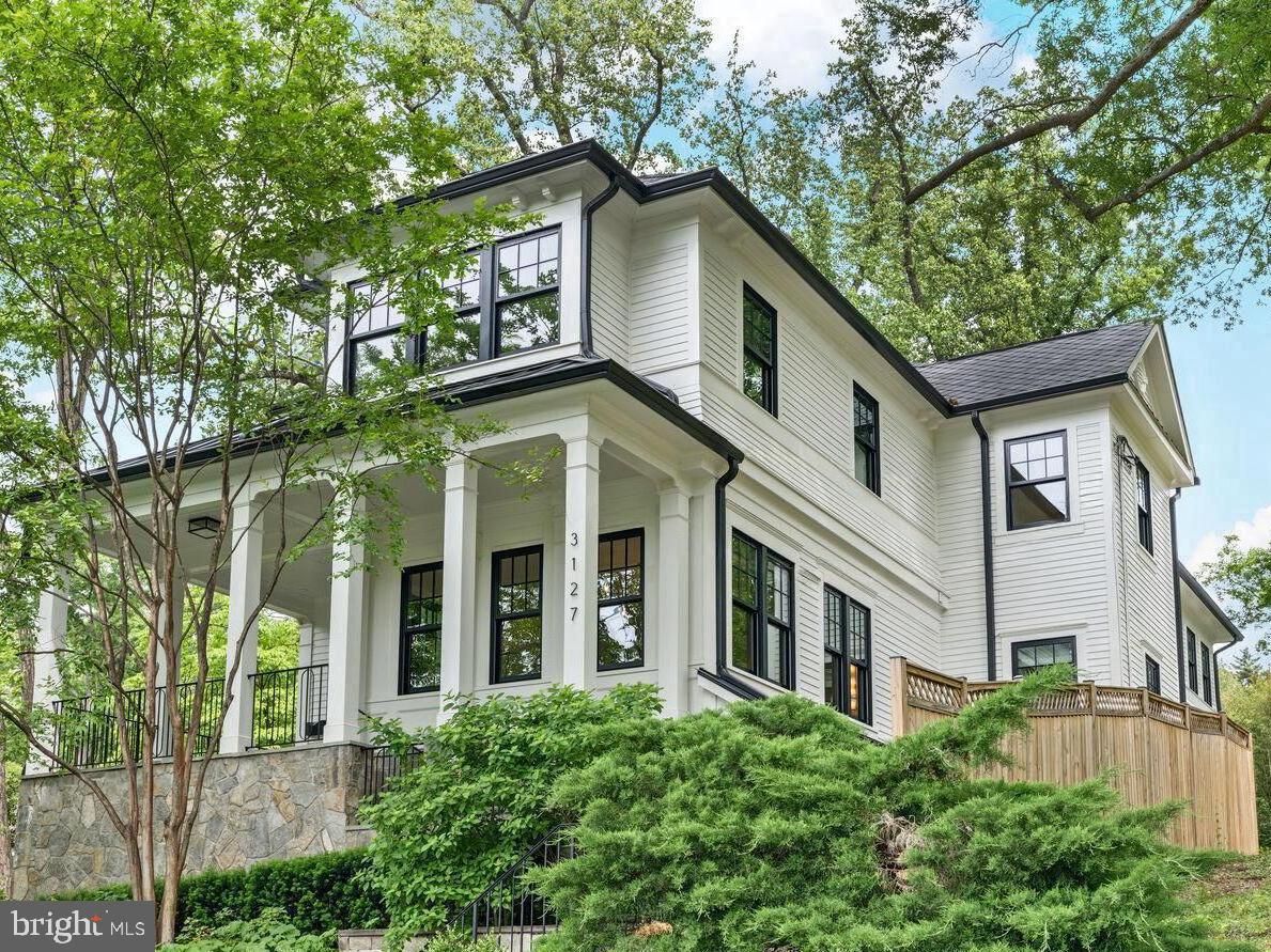 Beautifully built in 2018 and meticulously maintained and enhanced by the current owners, this expansive home features 7,700SF of luxury living across three finished levels with elevator access to all. The light-filled main level has an open floor plan with 10-foot ceilings, an elegant foyer, music/sitting room, formal living and dining rooms, private enclosed office, and powder room. Perfect for entertaining and everyday living, the spacious family room and adjacent gourmet kitchen provide a wonderful gathering place. The kitchen features a large center island with waterfall countertops, top-of-the-line appliances, breakfast nook, built-in desk area, and butler’s pantry with a large closet and second dishwasher. The inviting family room includes custom built-ins, a gas fireplace, and French doors that lead to a private patio with a built-in gas grill. The second level is complete with a luxurious primary suite with private balcony, dual custom walk-in closets, and a spa like en-suite bath with marble finishes, soaking tub, and heated floors. Also found on this level are three additional bedrooms with en-suite baths and walk-in closets, as well as a convenient upper-level laundry room. The walkout lower level is outfitted with full size windows, 9 foot ceilings, and access to the rear terrace, making the space inviting and functional. This level includes a large recreation room with gas fireplace that is open to the game room (optional office #2), stylish bar area with a wine refrigerator and dishwasher, bedroom #5, and full bath #5.  The mud room with cubbies and two car garage with built-in cabinets make staying organized easy. Each level enjoys it’s own outdoor space with slate terraces on the main and lower levels, primary bedroom balcony with tree top views, and a professionally landscaped and fenced rear yard with green space. Luxury finishes throughout including custom millwork, wallpaper accents, integrated speakers, mounted televisions, light fixtures, private elevator, three-zone HVAC system, and more. Located just minutes from Georgetown, Virginia, and Maryland, as well as easy access to all area airports, this stunning home combines timeless elegance with modern amenities in one of D.C.'s most coveted neighborhoods.