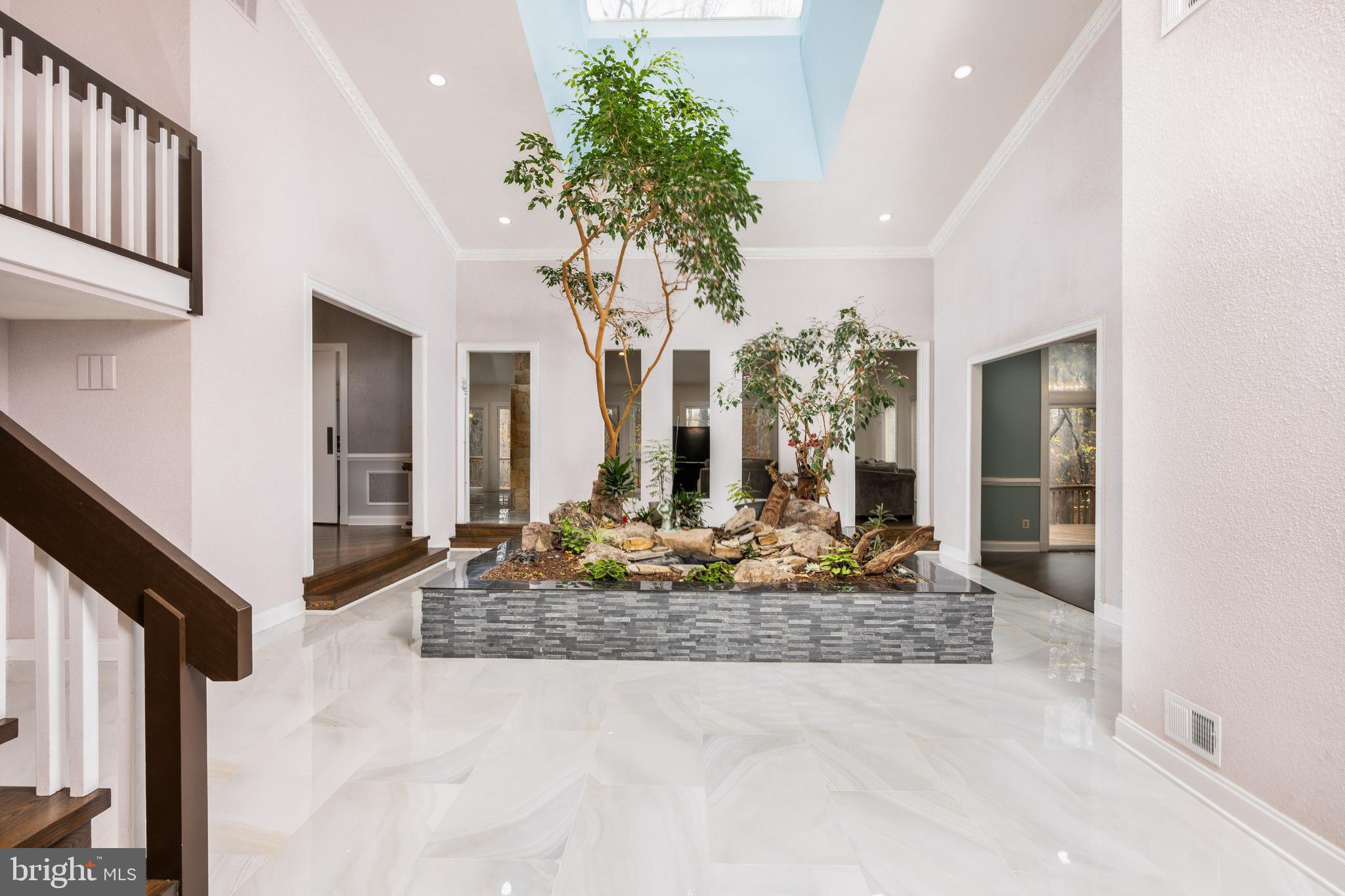 ***Welcome to this spectacular custom-built contemporary masterpiece, designed by the renowned architect JP Kollar. Located in the prestigious Kentsdale Estates, this one-of-a-kind home offers over 10,000 square feet of luxurious living space, including a heated indoor pool, a newly renovated kitchen, ROOF less than 10 years, two new HVAC (2023), and a stunning two-story foyer with an interior garden that exudes Zen-like calm. The home features 4 bedrooms, 5.5 baths, and has been meticulously updated with the finest finishes throughout.

As you enter through the glass-tiled foyer, you are greeted by the striking indoor landscaped garden, bathed in natural light from a large skylight above. Framed in stone and granite, the garden is a peaceful oasis filled with towering lush greenery, a soothing water feature, and sculptural stones, creating a serene ambiance that flows seamlessly into the surrounding spaces. Expansive floor-to-ceiling windows bring the outdoors in, filling the home with light and offering breathtaking views of the private 3.25-acre lot.

The open-concept great room and kitchen are designed for modern living and entertaining. An elegant two-sided wood-burning stone fireplace anchors the space, adding coziness and warmth. The chef’s kitchen boasts luxurious countertops, a spacious waterfall island with built-in storage, chic pendant lighting, a double oven, a smart Samsung refrigerator, a five-burner gas cooktop, a two-burner electric cooktop, and a stylish glass backsplash. Modern tile flooring completes the sophisticated design. The adjoining den, great room, and kitchen all feature gleaming hardwood floors, crown molding, and sliding glass doors that open to a wrap-around deck—perfect for al fresco dining and enjoying the scenic surroundings.

The expansive primary suite is a true sanctuary, accessed via a private pocket door. With hardwood floors, a wood-burning fireplace, and ample closet space, this retreat is designed for ultimate comfort. The sun-filed en-suite bathroom features a large skylight, creating a spa-like atmosphere. An adjoining office, complete with a second wood-burning fireplace and custom built-ins, offers the perfect space for work or relaxation. At the other end of the foyer is the secondary suite, also with hardwood floors, a walk-in closet, and an en-suite bathroom, providing comfort and privacy for family or guests. Additional amenities on this level include a beautifully updated powder room and a laundry/mudroom with abundant storage and exterior access.

Upstairs, the loft area is complemented by a third bedroom with a full bathroom, providing a private retreat for family or guests.

The lower level is a true entertainer’s dream, showcasing a fabulous glass-enclosed full-sized heated indoor pool, complete with an electric cover and a hot tub. A full bathroom with a shower adds convenience. The vast recreation room features a wood-burning fireplace, a large bar, and access to a lower patio for outdoor entertainment. This level also includes a spacious fourth bedroom, a renovated full bathroom, and extensive storage. A versatile unfinished bonus room with French doors and windows offers endless possibilities for a home theater, gym, or additional living space.

Rounding out this exceptional property is a side-loading three-car garage, offering ample space for vehicles and storage.

Conveniently located just minutes from Potomac Village, Cabin John Village, and major highways (I-270 & 495), this home offers the perfect balance of privacy, luxury, and accessibility. A true gem—don’t miss the opportunity to make this spectacular property your own!