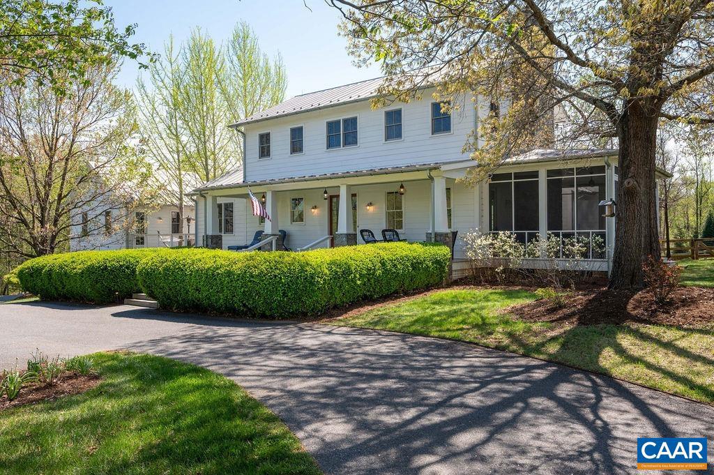 Tucked away on a quiet lane in the heart of Crozet's picturesque wine country, this stunning custom-built white farmhouse w/ metal roof & detached garage / apartment offers sophisticated luxury & timeless design. The current owners have meticulously renovated & upgraded nearly every aspect of the home, elevating it into one of the area?s most refined & livable residences. The exceptional kitchen features custom inset cabinets, farm sink, quartz "cement-style" counters, Wolf, Sub-Zero & Fisher/Paykel appliances. The main-level primary wing enjoys it's own soapstone butler's pantry, office, custom closets & private patio. New primary bath features gorgeous dual vanities, etched glass shower & tumbled brick tile. The detached apartment w/ full bath provides wonderful space for guests, recreation or home office. Designed to maximize the views & tranquil setting, the home offers deep covered porches, bluestone patios, tiered lawns & screened porch w/ stone wood-burning fireplace. Artfully uplit mature ginkgo trees growing through the rear deck create an unforgettable al fresco dining experience. A truly magazine-worthy residence!,Painted Cabinets,Quartz Counter,Wood Cabinets,Exterior Fireplace,Fireplace in Living Room