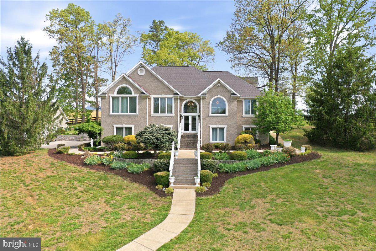 Perched on five breathtaking acres with panoramic Shenandoah Valley views, this exceptional country estate offers a rare blend of luxury, privacy, and natural beauty. From spectacular sunsets over the mountains to vibrant gardens filled with irises, fruits, and vegetables, every inch of the property celebrates the beauty of Valley living. Enjoy the tranquility of the countryside while remaining just minutes from historic downtown Luray, upscale dining, Luray Caverns, Skyline Drive, and endless outdoor recreation.

This all-brick 4-bedroom, 4-bath residence showcases timeless craftsmanship and thoughtful design throughout. Intricate hand-carved woodwork, custom trim, and elegant staircase details create a warm yet sophisticated atmosphere. The spacious main-level primary suite provides a private retreat, while the beautifully appointed great room opens to a stunning sunroom surrounded by glass and filled with natural light. Recent updates include all new appliances, HVAC system, and Roof, offering modern comfort and peace of mind. Step outside to the expansive deck and take in the surrounding mountain and countryside views.

Designed for both relaxation and entertaining, the grounds feature a stone patio and fire pit perfect for gathering with family and friends. A separate hillside studio, currently used as a year-round greenhouse, offers incredible flexibility. Complete with its own balcony overlooking the property, it could easily become an artist's studio, home office, guest retreat, or wellness space.

An impressive 1,200-square-foot detached three-car garage completes this remarkable offering. Whether tending the gardens, entertaining outdoors, exploring nearby hiking and fishing destinations, or simply enjoying the peaceful setting, this extraordinary Shenandoah Valley retreat offers an unparalleled lifestyle in one of Virginia's most scenic locations.