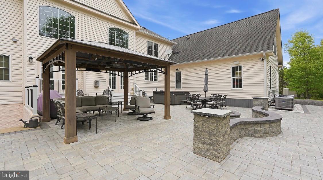 Perfect Multi-Generational Estate with Full In-Law Suite | 2 Kitchens & Smart-Home Integration
Experience a rare combination of massive scale, modern sophistication, and complete privacy on nearly two wooded acres in Gainesville. Originally built in 2008 and meticulously reimagined with over $200k in luxury upgrades in 2023, this 8-bedroom, over 7,000-sq-ft of beautiful living space, there is room for everyone.  The home showcases timeless architecture with striking stone and siding and best of all, , there is NO HOA, meaning you have full freedom to enjoy your property.
The "House Within a House" (Multi-Generational Luxury):
This isn't just a large home; it’s a versatile sanctuary. The main level anchors daily life with a gourmet kitchen featuring high-end appliances, a large center island, and an open flow into grand formal and casual spaces.  Master bedroom on main level, 3 additional bedrooms (1 en-suite and 1 jack and jill) upstairs with a 4th bedroom above the garage (en-sute) Basement has 3 additional bedrooms and 2 full bathrooms, laundry room, kitchen and living room – creating the perfect environment for an in-law suite, guest quarters, or long-term multi-generational living without compromising privacy.
A Smart-Home Powered Lifestyle:
For the tech-forward buyer, this estate is fully equipped for the future. The home is integrated with aControl4 Smart Automation System where luxury convenience is built-in, from the 85-inch mounted entertainment system to the Tesla charger in your conditioned 3-car garage, which features its own dedicated HVAC system.
Reimagined Backyard Oasis:
Step outside to a completely private retreat backing to lush trees. Your new 40' x 45' stone patio is the ultimate stage for sunset gatherings, unforgettable summer parties, featuring a built-in firepit, gazebo, hot tub, and integrated outdoor audio. Whether you’re hosting dozens on the expansive driveway or enjoying a quiet morning in the primary suite’s spa-inspired bath, every detail has been curated for an elevated lifestyle.
Location & Scale:
Space: 8 Bedrooms, 6.5 Baths across three finished levels.
Practicality: Massive Parking, oversized heated 3-car garage plus driveway space for 12 cars, boats, or an RV.  Fresh whole-house paint, new lighting, and relocated HVAC units for maximized outdoor use.
Commuter's Dream: Peaceful country feel, but only minutes from Interstate 66, Route 15, and Route 29.
