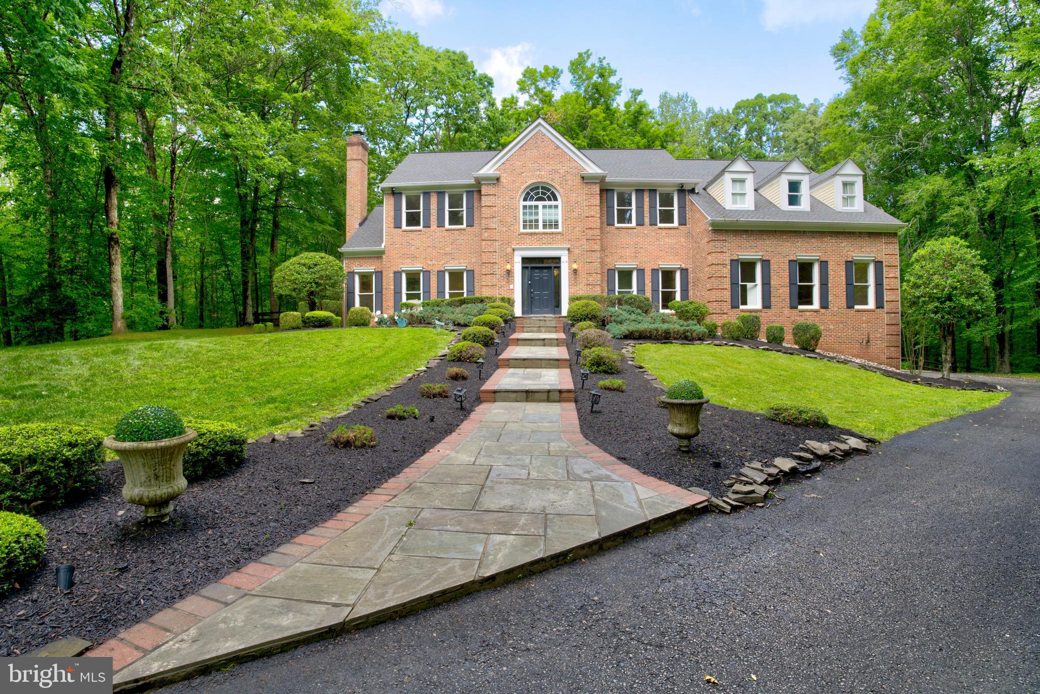Welcome to 12410 Clifton Hunt Drive, an exceptional Colonial estate nestled on five private wooded acres in the sought-after Clifton Hunt community. This stately residence offers the rare opportunity to experience peaceful country living while enjoying the convenience of Northern Virginia's premier amenities just minutes away.

Spanning over 6,200 square feet, this elegant home features 6 spacious bedrooms and 6.5 bathrooms, including three private primary suites—one of which is located on the main level with a fully renovated, handicap-accessible en-suite bathroom and dual walk-in closets.

From the moment you enter the grand marble foyer, you’re greeted with warmth, elegance, and thoughtful architectural design. Soaring ceilings, expansive rooms, and custom finishes set the tone throughout the home. The formal living and dining rooms flow seamlessly to the oversized entertainment deck through beautiful French doors, making indoor-outdoor gatherings a breeze.

The heart of the home is the gourmet kitchen—designed for both serious cooking and casual family life. It boasts custom KraftMaid cabinetry, granite countertops, a large center island, and top-of-the-line Viking and Bosch appliances. A charming breakfast nook with a bay window overlooks the serene backyard.

The adjacent family room is inviting and spacious, featuring a wood-burning fireplace, wet bar, coffered ceilings, and two grand Palladian French doors leading to the deck and backyard—ideal for entertaining or simply relaxing in nature.

Upstairs, the expansive primary suite is a true retreat, offering a private sitting room, updated en-suite bath, custom walk-in closet, and a private balcony overlooking the treetops. Additional upper-level bedrooms include two more en-suites, each thoughtfully updated with modern finishes.

The fully finished walk-up basement includes a guest suite, full bath, custom wet bar, and a dedicated movie theater room with 7-speaker surround sound—perfect for cozy nights in or entertaining guests.

Outside, you'll find a fully fenced backyard with split rail , custom pergola, 6-person spa, and plenty of open space for gardening, games, or peaceful walks beneath mature trees.

Notable recent updates include:

2018: HD architectural shingle roof, 3 skylights, new gutters & downspouts.

2021: New Carrier heat pump and coil.

2023: New HVAC (upstairs), recessed smart lighting (Alexa-controlled), luxury Karastan carpet in all bedrooms, fully renovated en-suite bathrooms, custom wet bar, new ceiling fans, new Samsung smart washer/dryer, movie theater install, and main-level hardwood refinishing.

2024: New garage doors.

2025: Home fully painted

Whether you're entertaining, relaxing, or working from home, 12410 Clifton Hunt Drive offers space, flexibility, and timeless elegance in one of Northern Virginia's most picturesque and private communities.