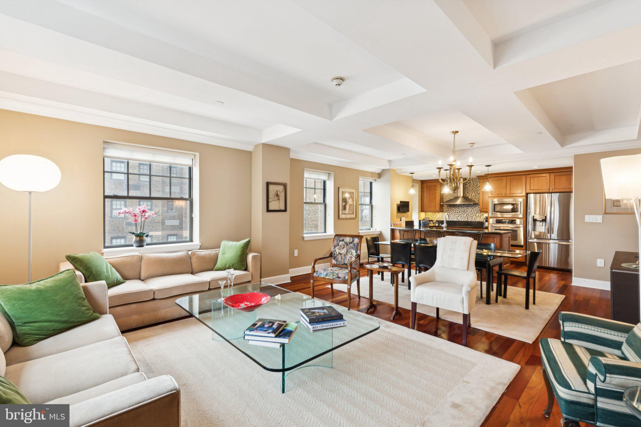 Beautifully appointed corner three bedroom with Center City views at The Warwick Condominiums. This expansive home features generously sized rooms, incredible entertaining space and architectural details, beautiful natural light from oversized windows, custom built-ins, high-end finishes, and see-forever city views to the south and east. Enter into a welcoming foyer with deep coat closet and long hallway. The grand, open great room boasts wonderful natural light from two walls of windows, a spectacular coffered ceiling, a high-end kitchen, and ample space for living, dining, and entertaining. Open to the dining area is the beautifully appointed chef's kitchen featuring rich wood cabinetry, granite countertops, designer tile backsplash, deep stainless steel sink with garbage disposal, pantry closet with built-ins, breakfast bar, and stainless steel appliances, including a built-in microwave and oven, electric range with hood, dishwasher, and French door refrigerator with water dispenser and freezer drawer. The expansive primary suite offers excellent natural light and skyline views, another coffered ceiling, built-in mirrored vanity, incredible closet space including two walk-in closets with wood built-ins, and a marble-appointed ensuite bathroom boasting a wooden double vanity, deep soaking tub, and glass-enclosed walk-in shower. The second bedroom is currently being used as an office and features a built-in wooden desk with storage, walk-in closet, and marble-appointed ensuite bathroom with wood vanity and glass enclosed walk-in shower. The third bedroom/den has a custom built-in entertainment center with ample storage and two closets. It enjoys use of an adjacent full bathroom with walk-in shower and marble tilework. Additional home highlights include laundry closet with stacked washer/dryer, baseboard molding, recessed lighting, rich hardwood floors, and beautiful millwork and trim throughout. Located on the top eight floors of the legendary Warwick Hotel, these beautiful condominiums feature high end finishes and features. The building sits one block away from Rittenhouse Square. Residents of The Warwick enjoy the same amenities as hotel guests including 24-hour door-man service, a state-of-the-art fitness room, and the use of three restaurants on the ground floor for additional fees.