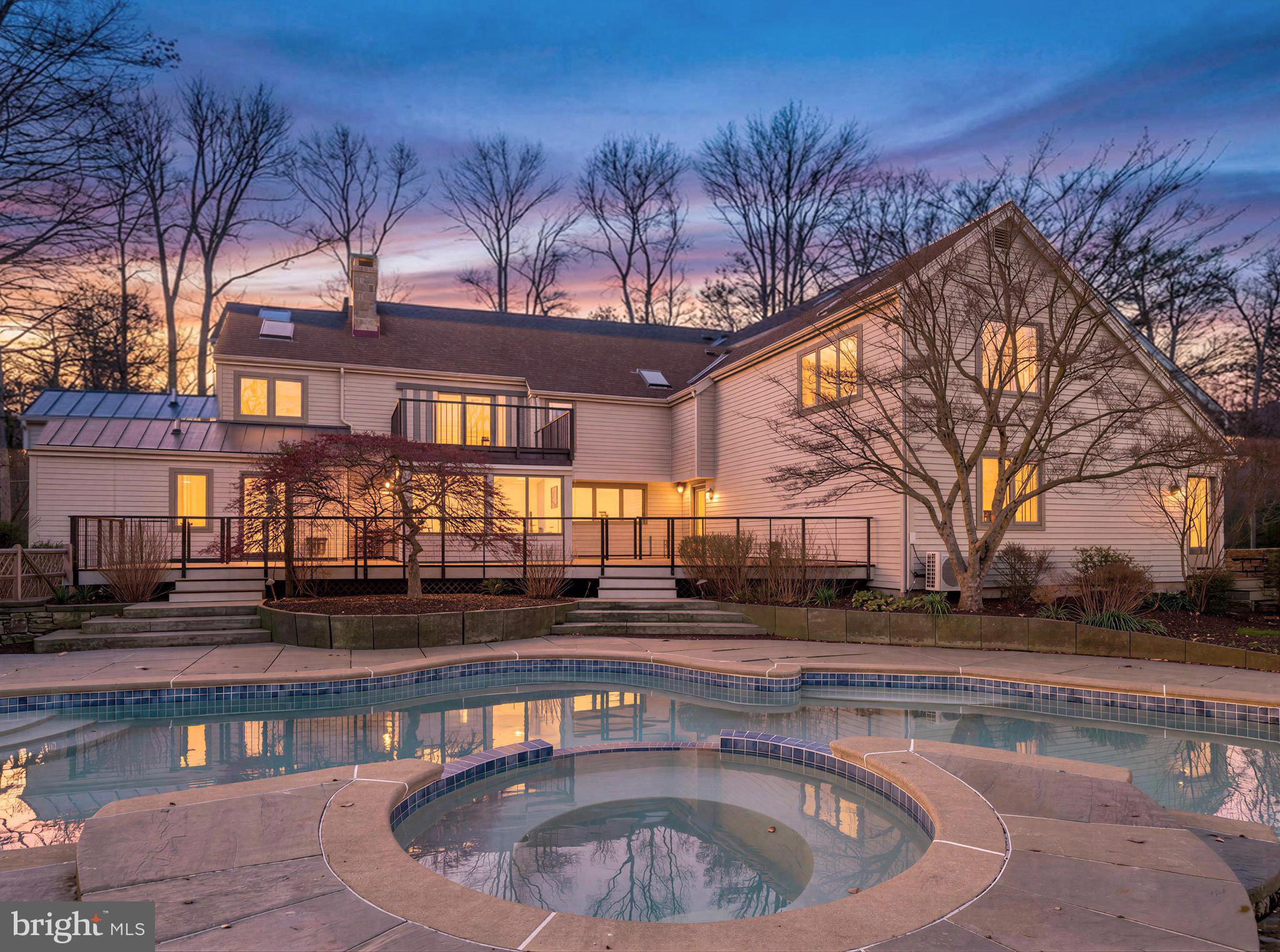 Set gracefully on 10 private acres in the bucolic River towns area of Bucks County, PA, this remarkable estate offers a rare sense of seclusion, where architecture, art and land unite in quiet harmony. A long, tree-lined drive winds past custom Weatherwood Design gates, revealing a home and charming buildings that feel both grounded in nature and thoughtfully designed by Robert Goodwin for refined living. Inside, light and texture define the interiors. Floor-to-ceiling windows frame the intriguing land, while rich hardwood floors and four stone fireplaces designed by Steven Snyder bring warmth and character to the home’s living spaces. The great room serves as a natural gathering place, effortlessly connecting to a series of intimate and inviting rooms, including a library with a custom fireplace and an additional living area with bespoke built-ins. The chef’s kitchen is both functional and beautifully appointed, offering generous cabinetry, Sub Zero and Wolf appliances, and expansive counter space. A screen porch/three-season room is an ideal setting for year-round enjoyment. Just beyond, the bluestone veranda, saltwater pool and spa are excellently positioned, creating a natural extension of the home’s indoor living. The main-level primary suite offers ease and comfort, with direct access to the outdoors and a well-appointed spa bath. Upstairs, another primary suite unfolds as a private retreat, complete with two walk-in closets, a steam shower bath and soaking tub. Dual terraces provide unique vantage points to overlook the property. Additional spaces include a flexible studio/meditation room, a playful lofted child's retreat, and well-proportioned guest accommodations. Radiant heated floors enhance the full baths. A private office above the attached two-car garage provides a quiet workspace with separate access, while two detached outbuildings expand the possibilities—one featuring a garage with studio and full bath above, and another beautifully finished structure suited for creative pursuits, wellness, or studio use. The property is near the Delaware River and the river towns of Point Pleasant, Frenchtown, and New Hope for hiking, boating, antiquing, and dining. 90 minutes to Manhattan, 70 minutes to Philly, 50 minutes to Princeton.