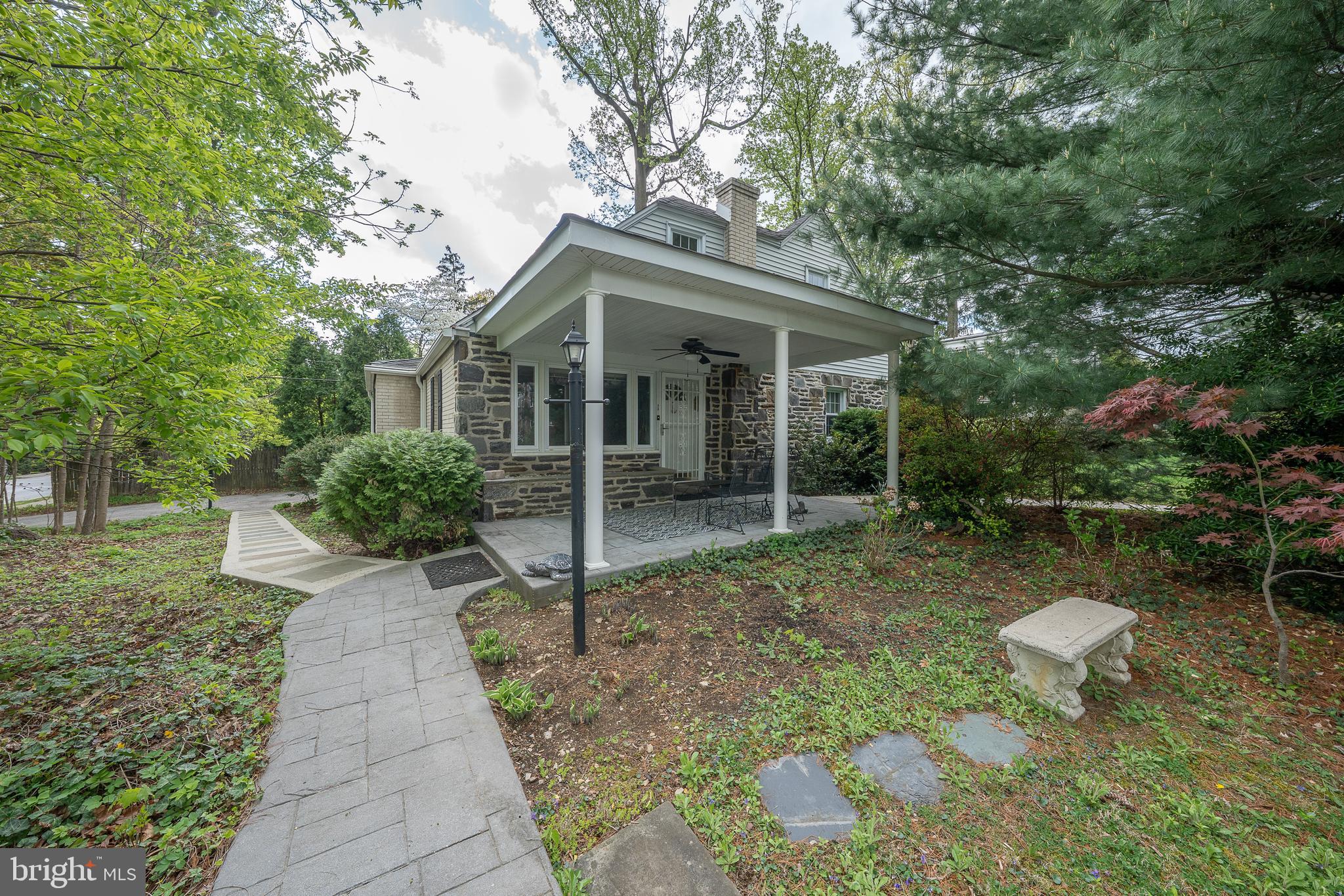Don't miss this RARE opportunity to live in sought after neighborhood nestled between Villanova University campus and the R5 Rosemont train station. Walk up to the inviting large covered front patio to enter the front door. The main entrance leads into the spacious living room /dining area with large picture window. There have been many family dinners and parties in this dining area, and it is large enough to fit a full formal dining room set.  The dining area is adjacent to the oversized kitchen with counter height seating.  Cabinets with pull out shelves in this section.   The painted brick wall is the backdrop for another eating area.  Double windows overlook spacious side yard with rear door access to an oversized driveway.   There is also a half bath conveniently located adjacent to the kitchen.  There is a pocket door from the LR leading to the first-floor bedroom area.  There is a large oversized tiled full bath in the hall with extensive cabinetry.  This hallway leads to the large corner bedroom with walk in closet with a window.  There is another bedroom facing the front of the house.  This area could be easily modified to a private FIRST floor primary bedroom suite.

The stairs leading to second floor are in the living room near the front door.  These hardwood stairs lead to two  nicely sized bedrooms and a hall bath with oversized walk-in stall shower.  There is an exterior door leading to second floor deck and outside staircase leading to side yard, offering private access.  Perfect for in-laws, adult children, etc.
Both floors have the original hardwood floors throughout.
Returning to main floor there is access to the partially finished basement.   The basement is heated with several spaces, perfect for exercise and/or play area, workshop, etc.  There is a separate utility room.  The washer/dryer is in the basement and there is anoutside entrance.