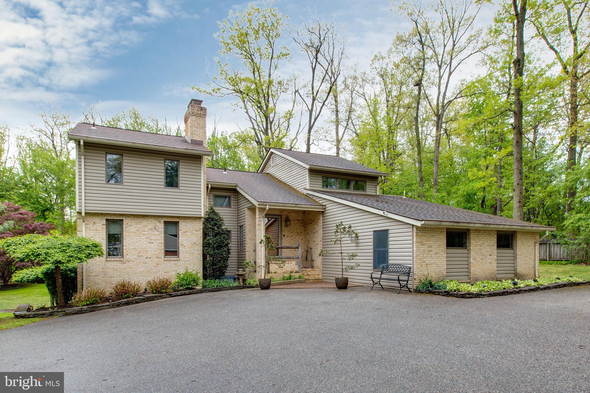 Beautiful custom home on a 1.5  acre  private woodland lot . Features 4BR/3BA with 2 half BA, including a rare MAIN LEVEL IN-LAW SUITE with a private entrance. Enjoy a designer kitchen, hardwood floors, and a spa-like master bath, along with an upgraded heating furnace (2024). The finished walk-out basement leads to an outdoor oasis with professional hardscaping, a two-tier deck, and multiple patios. Situated in a premier school district minutes from everything. The perfect combination of privacy, style, and convenience!
