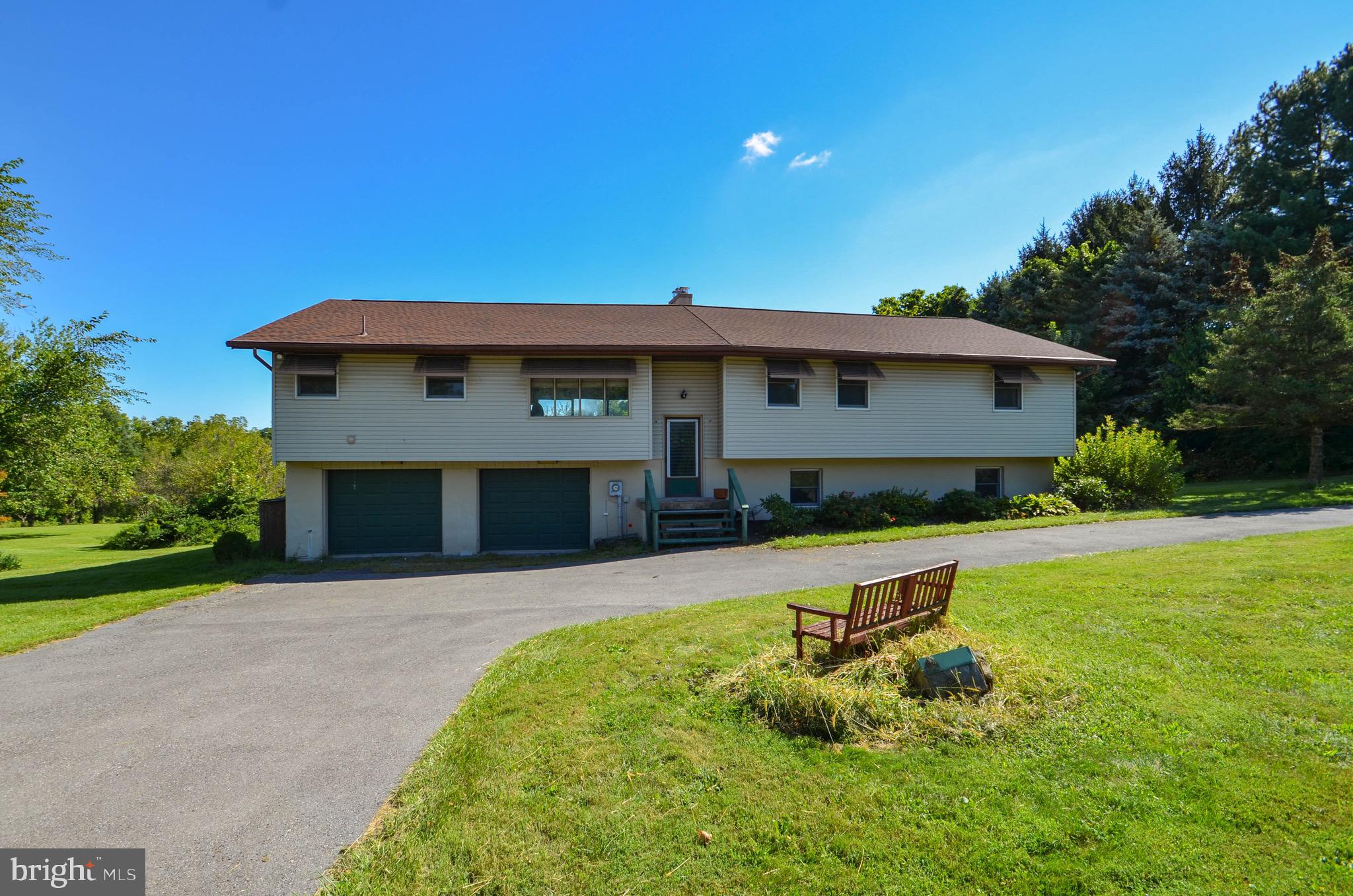 Private, secluded, country living with so much potential! This unique Bi-level home has a desirable wide open floor plan flooded with large windows & natural light throughout! Situated on an open 2.17 acre park like setting offering a mix of Arborvitaes, apple trees & other mature trees! As you arrive at this 3000 sq ft home you are welcomed by a horseshoe driveway. Once inside, the open living space is showcased w/ large windows & gorgeous views. The living room includes a wood stove to keep you toasty, the dining & kitchen area have tons of cabinet & counter space. Off the living area, there is a convenient laundry room w/ utility sink, washer, dryer & cabinets, a 2nd set of stairs to the lower level & pull down attic storage. On the other side of the home sits a spacious master bedroom suite w/ sliders to a balcony, in need of repair, attached full bath w/ shower & a dressing room or office space. 2 more bedrooms w/ large closets & full bath complete the main floor. Downstairs would make a great space for an in-law suite or extended living. There is a bar area w/ a kitchenette, sink, gas stove & countertop, there is an open family room/ rec room w/ a wood burning stove, a third full bath w/ shower, as well as ample storage. The oversized 2-car garage leads out to the back yard w/ a covered patio & large shed. Nestled on a picturesque country setting yet conveniently located minutes from Rts 78/22/100/222/476. Bring your vision to modernize this 1970s home to your desire!