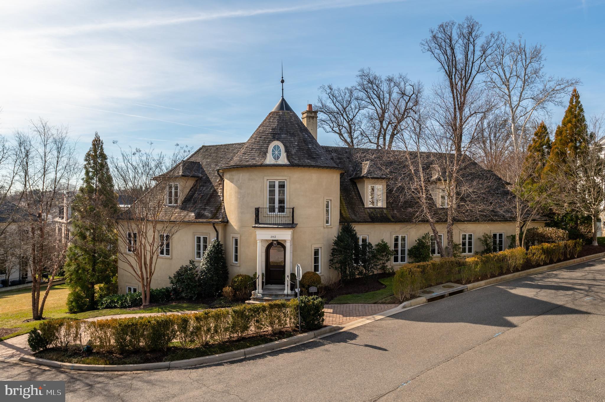 Perched on a private quarter acre lot in Phillips Park, 2113 Dunmore Ln is an extraordinary showpiece built in 2009 by premier builder Jim Gibson in collaboration with renowned BarnseVanze Architects. The prestigious stucco and stone façade transports you to the finest villas of the South of France with lush landscaping and serene, south-facing gardens encompassing the one-of-a-kind oasis. Offering 5 Bedrooms, 5 Full Bathrooms and 2 Half Bathrooms across 3 finished levels, the property spans approximately 7,850 total square feet. Meticulously curated interiors and impeccable design notes are on display throughout the home and include stunning coffered ceilings, gleaming hardwood flooring, beautiful built-ins, crown moldings and 9’+ ceilings. An outdoor Kitchen and idyllic covered porch lines the rear of the residence, providing the perfect setting for al fresco dining or large-scale gatherings. The home’s unique layout seamlessly blends exquisite interiors with its enviable exterior amenities to provide a tranquil sanctuary and offer effortless entertaining. 
The entry Foyer, complete with a grand spiral staircase, welcome’s you to the Main Level’s principal living spaces boasting 10’ ceilings, abundant natural light and direct access to the home’s private, tree-lined lawn. A sprawling Primary Suite is conveniently located on the Main Level and showcases 2 Walk-In Closets, an abundance of windows that flood the space with light, direct exterior access and a luxurious Primary Bathroom complete with dual vanities, large soaking tub, stall shower and separate water closet. An attached 2-Car Garage is accessible from the Main Level and features built-ins for extra storage. 
The Upper Level features the home’s guest quarters which include 3 Bedrooms, each with an en-suite Bathroom, as well as a Laundry Room, an expansive Walk-In Closet and Attic space for additional storage. The multifunctional Lower Level offers something for everyone with a home Theatre/Movie Room, Exercise Room, Wine Cellar, Laundry Room and a 5th Bedroom with Full Bathroom. 2 Additional Driveway Parking spaces round out the abundant amenities this residence has to offer.