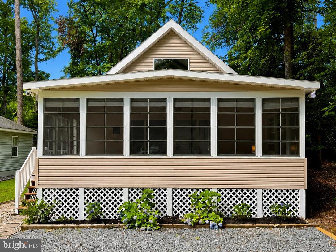 Discover the perfect blend of comfort and coastal living at 67 Seafarer Lane in the desirable Ocean Pines community! This well-maintained 3-bedroom, 1.5-bath home offers 1,584 square feet of inviting living space nestled on a spacious wooded lot, providing both privacy and a peaceful setting.

A large front sunroom welcomes you home and offers the perfect spot to enjoy your morning coffee, read a good book, or relax with friends throughout much of the year. Inside, you'll find a bright and comfortable floor plan with generous living areas, abundant natural light, and an eat-in kitchen that's ideal for everyday living. The main level also includes two spacious bedrooms with a conveniently located full bathroom.  A craftsman staircase leads to a second-level loft that includes a third large bedroom, storage closet, and a half bath, making the home well suited for full-time living, weekend escapes, or an investment opportunity.

Step outside to enjoy the large yard with endless possibilities for outdoor entertaining, gardening, or simply enjoying the peaceful surroundings. With ample parking and a location on a quiet street, you'll appreciate the balance of tranquility and convenience.

Ocean Pines offers a variety of recreational amenities available to residents, including parks, playgrounds, walking and biking trails, marinas, golf, indoor and outdoor pools, tennis and pickleball courts, a yacht club, beach club, and year-round community events. Conveniently located just minutes from Ocean City, Assateague Island, and the charming shops and restaurants of historic Berlin, this home puts the best of Maryland's Eastern Shore within easy reach.

Whether you're searching for a primary residence, a vacation retreat, or an investment opportunity, this home offers exceptional value in one of the area's most desirable coastal communities.