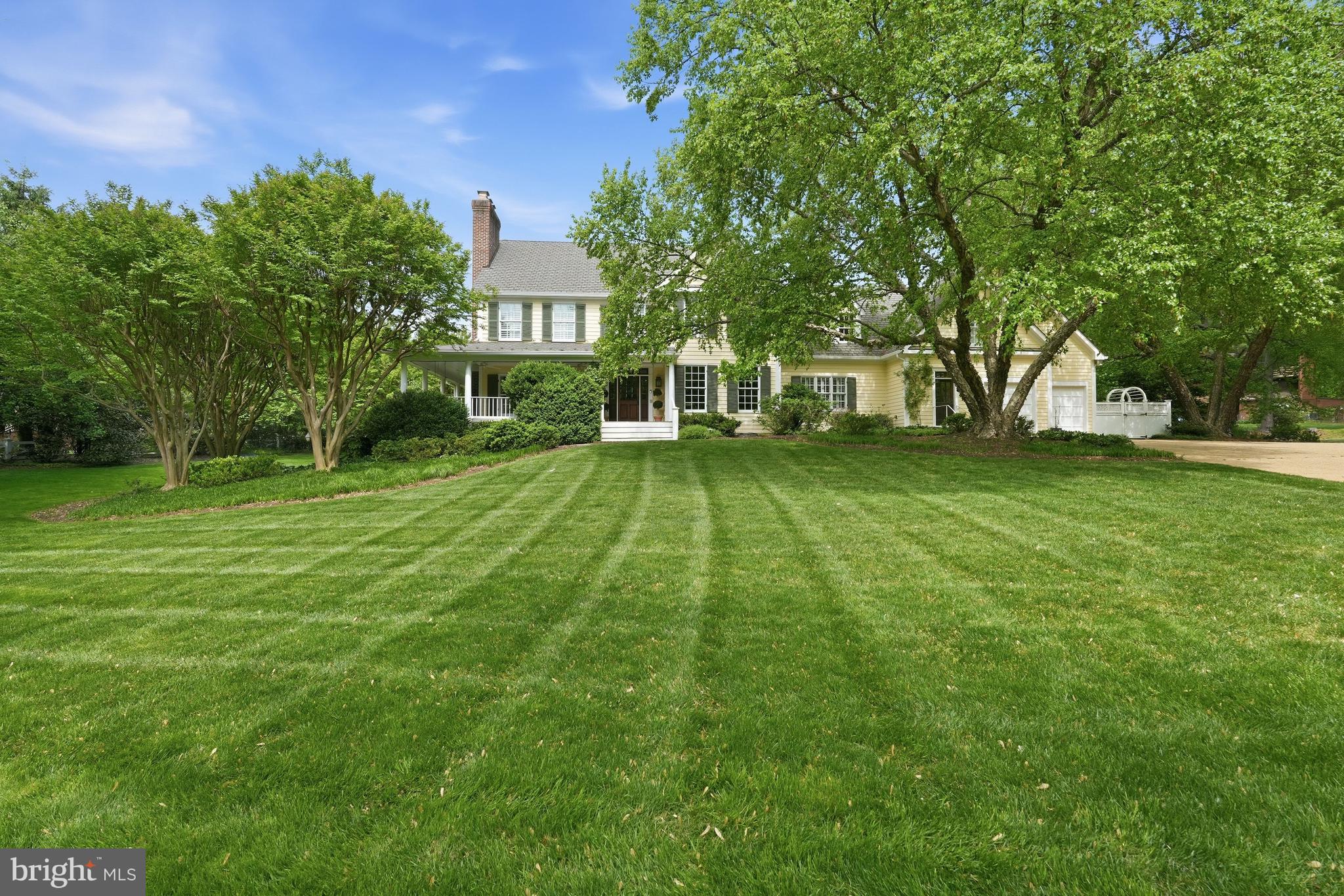 2120 Elliott Avenue is one of Franklin Park's most recognizable homes—an iconic yellow farmhouse set on over an acre of sweeping, tree-framed grounds. Introduced by a broad, manicured lawn and anchored by mature trees, the home presents with a sense of permanence and quiet distinction rarely found.
Its authentic wrap-around porch and classic proportions define a silhouette that is both familiar and timeless—capturing the essence of a true American farmhouse. The soft yellow façade, articulated with traditional detailing and balanced fenestration, reinforces the home’s warmth and approachability, while four fireplaces within speak to its history of gathering and lived-in elegance.  Renovations have been done over the recent years including the kitchen, all baths, lighting, furniture-grade built-ins and beautiful hand-scraped walnut hardwood flooring.

A gracious front approach leads to interiors that unfold with ease and authenticity. The foyer opens to a handsome library, setting a tone of understated refinement. Formal living and dining rooms flow naturally, offering a sense of proportion and continuity suited to both everyday living and entertaining. At the center of the home, a thoughtfully renovated kitchen integrates modern function with classic design, opening to the gracious family room and a lovely covered rear porch for a seamless indoor-outdoor connection.

The family room provides a relaxed, inviting counterpart to the more formal spaces, while a main-level bedroom suite—with full bath and private entrance and wetbar—offers exceptional flexibility for guests, multigenerational living, or a functional home office. A large mudroom and family powder room connects efficiently to the attached garage, reinforcing the home’s practical livability.

Upstairs, five bedrooms are well-scaled and thoughtfully arranged. The primary suite, recently updated, serves as a quiet retreat, while four additional bedrooms provide flexibility and comfort, supported by well-appointed baths and a large laundry room. The rear staircase leads to a landing with a fantastic upstairs family or playroom.  Character details such as window seats and sconces add to the charm.

The lower level extends the home’s functionality with endless possibilities.  Currently comprised of a recreation room, bedroom with separate door to the rear yard and a recently renovated full bathroom, as well as multiple flex spaces, an additional full bathroom, and a washer and dryer hookup for an additional laundry room if desired.   The walkout lower level gives direct access to the grounds of the property—creating a seamless extension of the living space.

Outdoors, the property unfolds with a natural rhythm—expansive lawn, mature canopy, and curated outdoor living anchored by a private patio with fireplace and built-in grille. The setting feels both open and protected, offering a rare balance of space, privacy, and connection to nature.

2120 Elliott Avenue stands as a true landmark offering—defined by authenticity, architectural character, and an irreplaceable setting within one of McLean’s most established and admired neighborhoods.