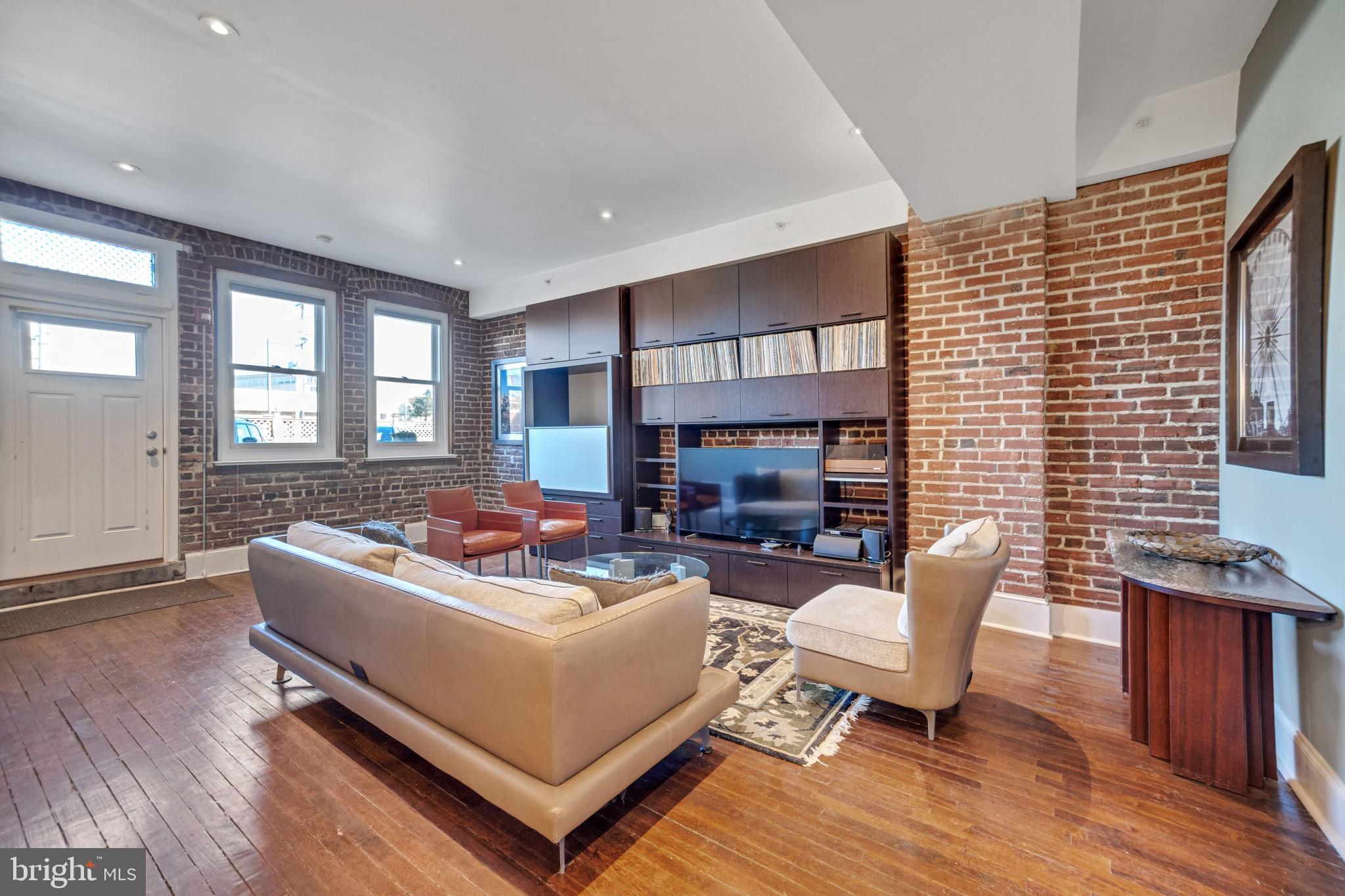 Welcome to 501 Vine St #8! This gorgeous 1 bed, 1.5 bath condo has an incredible amount of storage, it's own private spacious patio/garden and a parking spot located directly outside the unit. Enter into the bright, wide-open living and dining room space. You will be greeted by a gorgeous, exposed brick wall, high ceilings and original hardwood flooring. The open floor plan creates the perfect entertaining space. The sleek chef’s kitchen features dark wooden cabinetry, white stone countertops, subway tile, stainless steel appliances, a mini wine refrigerator and vented hood. The island provides plenty of room for dinner prep or dining and is complete with storage beneath and modern pendant lighting above. There is a large closet just off the kitchen which serves as a pantry or extra storage space. The beautiful hardwood floors continue into the bedroom suite. The bedroom features recessed lighting, two windows and is large enough to fit a king-sized bed. This space has a  generously sized walk-in-closet, complete with custom built in shelving. The primary bathroom features built in shelving, beautiful neutral grasscloth tile and a modern, floating double vanity. A pocket door adds privacy to the bedroom but a transom window above allows the natural light to pass through. A convenient half bath is located off the living / dining space so guests don’t need to enter the bedroom suite. A side door leads to the shared basement steps that take you to an extra-large, private and secure storage space. The front-loading washer and dryer and all mechanicals including the central HVAC system are all located in the basement. A unique feature of this home is the spacious patio / garden space right outside the front door. With a walk score of 94, this home is steps away from Franklin Square, historic sites and the fabulous shops & restaurants in Old City and Northern Liberties. It is a short walk to Center City and conveniently located near entrances to Rt 676 and the Ben Franklin Bridge.
*On-site parking, located right outside of the unit is available for an additional $250/month. Unit can be rented with or without parking.
*The entire unit has been repainted a neutral color.