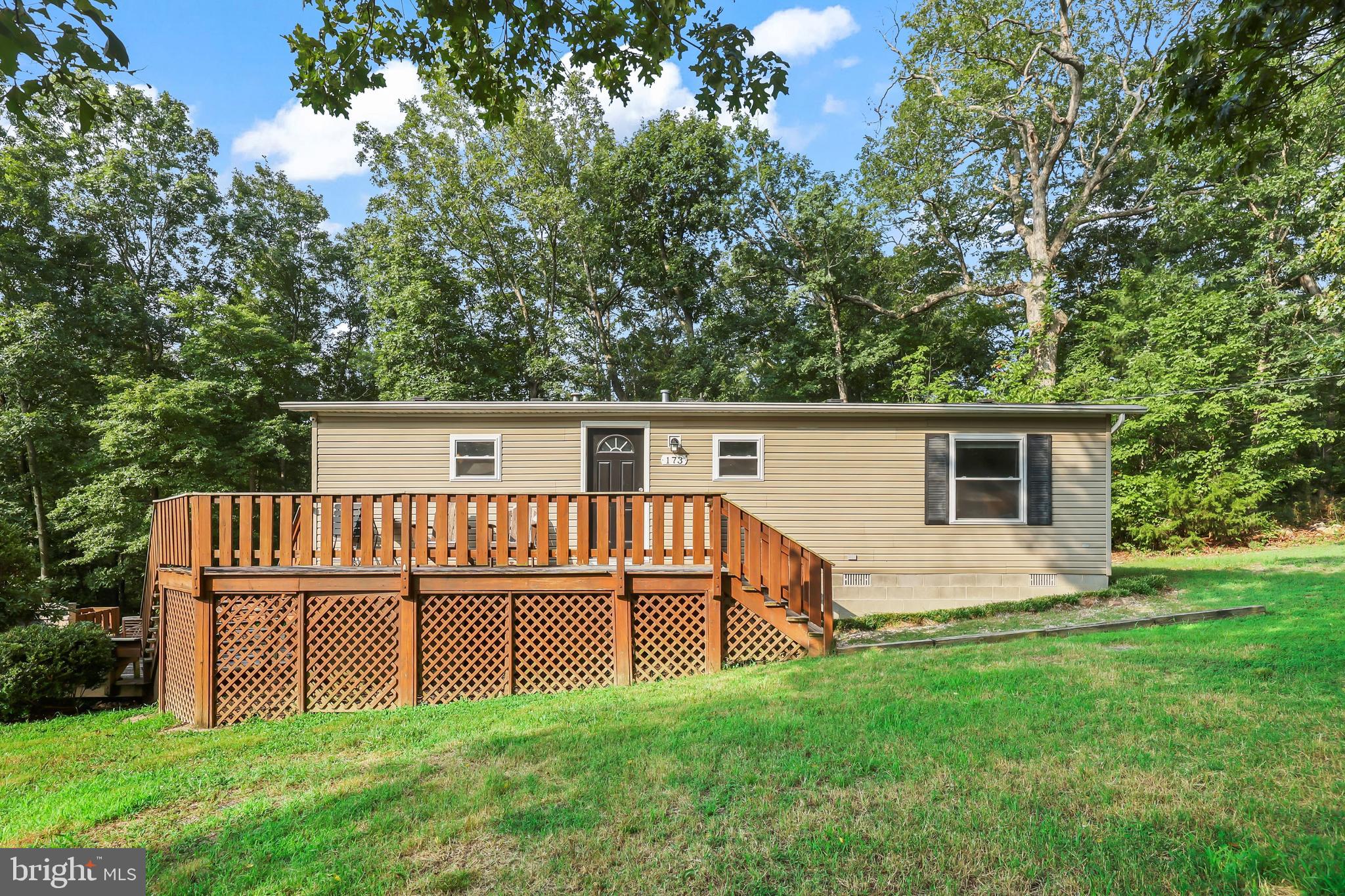 Charming two-bedroom, two-full-bath home situated on a permanent foundation and privately set on a beautiful 0.95-acre Lot #12 with its own well and septic system. Included is an additional adjoining 1.08-acre Lot #6, offering added privacy, expansion potential, or future building opportunities. The home features a Peat Moss septic system. Inside, the inviting living room showcases vaulted ceilings and a cozy fireplace with gas logs, creating a warm and welcoming atmosphere. Enjoy outdoor living on the spacious double-sided deck overlooking peaceful mountain views, with a lower-level firepit perfect for relaxing evenings and entertaining. Recent updates include windows (2023), front door (2023), blinds (2023), washer and dryer (2021), microwave (2024), and refrigerator (2024). Ideally located near Skyline Caverns, the Shenandoah River, fishing, canoeing, and river rafting, with easy access to Massanutten Resort and Bryce Resort for year-round recreation, dining, and outdoor adventure.
