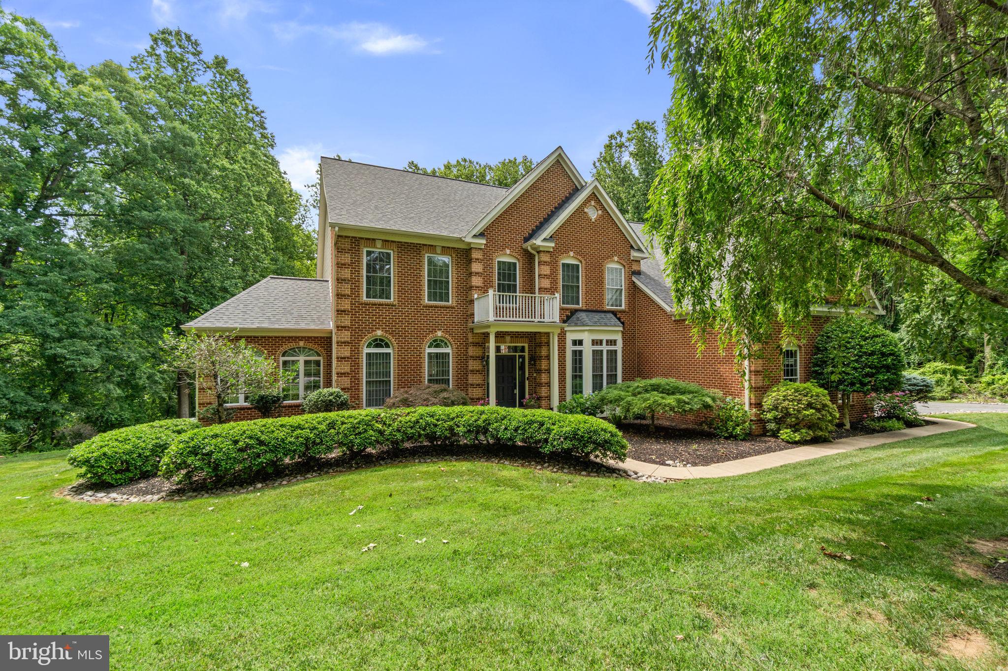 Elegant Colonial residence nestled on more than two picturesque acres in the serene setting of Tilyard Farms, offering a rare blend of privacy, timeless architecture, and thoughtful updates. Recent improvements include a roof (2022), HVAC system (2019), water heater (2022), washer and dryer (2024), upper and lower bathroom renovations (2025), kitchen renovation (2024), driveway (2017), Trex® deck (2016), retractable awning (2018), and gutters (2016). // A grand foyer is flanked by a formal dining room with a bay window and a formal living room that flows seamlessly into a sun-drenched sunroom with panoramic windows and a tray ceiling. Tucked away for privacy, a dedicated study provides an ideal work-from-home setup with a nearby powder room. At the heart of the home, the impressive two-story great room showcases a gas fireplace and triple French door access to the deck, creating a seamless connection between indoor and outdoor living. // Open to the great room, the beautifully updated eat-in kitchen (2024) combines style and functionality with granite countertops, a curved center island with breakfast bar seating, stainless steel appliances, pendant lighting, a decorative backsplash, crisp white cabinetry, and a charming breakfast nook framed by bay windows. A laundry room and access to the nearby garage complete the main level. // A lofted hallway overlooks the great room below and leads to the luxurious owner's suite, a true retreat featuring a spacious sitting room, and a spa-inspired ensuite bath with dual vanities, a dedicated makeup station, soaking tub, separate shower, a private water closet, and a large walk-in closet. Three additional bedrooms and two full bathrooms complete the upper level, including a thoughtfully designed shared bath serving two of the secondary bedrooms. // The walk-out lower level offers an expansive open space ready to be customized to fit your lifestyle, whether envisioned as a recreation room, fitness area, home theater, or additional living space, while also providing ample storage and a utility room. // Outdoor living is equally impressive. A low-maintenance Trex® deck installed in 2016, complete with a retractable awning added in 2018, overlooks the expansive backyard and wooded backdrop. A charming stepping-stone pathway meanders through the grounds to the lower-level exterior entrance.