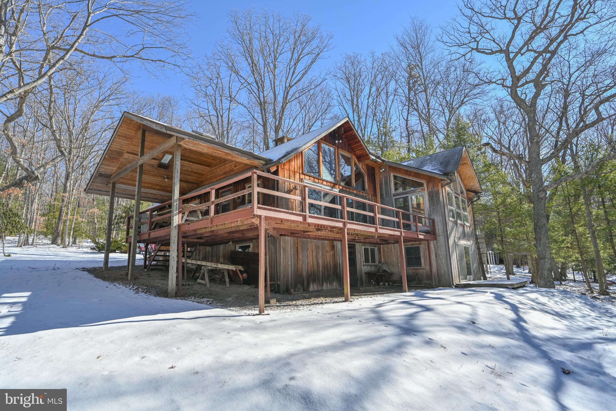 Deep Creek Lodge in Thousand Acres Lake and Golf Community. Southwestern exposure on 100' of gently sloped lakefront with an open floor plan. Massive native stone wood burning fireplace to knock the chill off year-round.  No shortage of natural light with a wall of glass overlooking the lake.  Large lakeside deck 
 that's partially covered is a great place to enjoy being outside, rain or shine. Minutes away is the Thousand Acres Golf Course. Across the street, a wooded one-acre lot is included for a total of two-acres in all.  A must see for those who prefer a private lodge style rustic lake life escape.