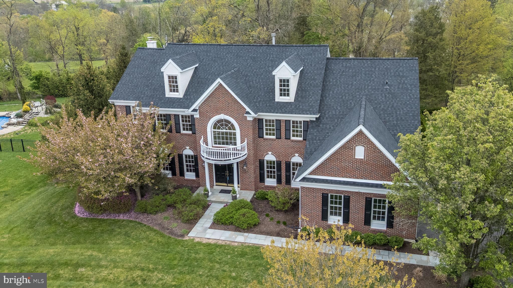 Welcome to 2517 Lockleigh Rd in the highly sought-after Estates at Dark Hollow. Set on a private, beautifully landscaped 0.86-acre lot, this impressive custom-built estate offers 4 bedrooms, 3.5 baths, and a seamless blend of timeless craftsmanship upgrades and modern comfort—all within award-winning Central Bucks School District. A newly installed bluestone walkway leads to a grand entrance, where a sweeping curved staircase and striking custom millwork create an unforgettable first impression. The formal living and dining rooms are elegantly appointed with crown molding, chair rail, wall sconces, and custom drapery—perfect for both everyday living and entertaining. A private office/library with custom built-ins provides an ideal work-from-home space. At the heart of the home, the expansive family room is filled with natural light from a dramatic wall of windows and anchored by a stunning stone wood-burning fireplace, flanked by custom built-ins. The adjacent kitchen features cherry cabinetry, granite countertops, stainless steel appliances, a brand-new backsplash, and a picturesque window overlooking the serene backyard. The bright breakfast room showcases a two-story bay window and sliding glass door leading to a freshly refinished deck—perfect for enjoying peaceful, park-like views. A rear staircase, spacious laundry room, and powder room complete the main level. Upstairs, the luxurious primary suite is a true retreat, offering a private sitting room with built-ins, two walk-in closets, and a spa-like bath with jetted tub, oversized shower, a dual granite vanity, and linen storage. One secondary bedroom includes an en-suite bath, while two additional bedrooms share a Jack-and-Jill bath with a dual vanity and a private shower/commode area. The expansive walkout basement offers incredible potential for future living space, featuring high ceilings, abundant natural light through three windows and two doors, a rough-in for a full bath, and direct access to a new bluestone patio—ideal for creating a fifth bedroom, guest suite, or entertainment area. Additional highlights include a new roof, newer HVAC systems, whole-house generator, new electrical panels, underground sprinkler system, new exterior shutters, and a 3-car garage with ample storage. The professionally landscaped grounds feature beautiful stonework and pathways, creating a peaceful, park-like setting. Enjoy direct access to the Warwick Township trail system for walking, running, and biking. Ideally located with easy access to NYC, Philadelphia, Doylestown, and New Hope, this home offers the perfect balance of luxury, privacy, and convenience. Schedule your private tour today—this is one you won’t want to miss.