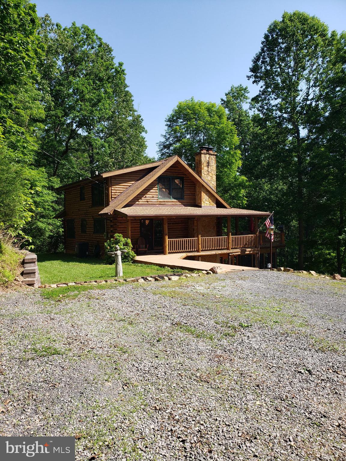 Private park like setting with a 3 level New England Log home enhanced with a wrap around covered porch, open deck on the main level and a three season screened porch off the lower level family room.
This property sits within a gated community along the clear, clean Cacapon River with a private access lot featuring a picnic area park with bathhouse and area to leave your canoes and kayaks safely.
The house has a bedroom and bath on each level for privacy with a wood burning stone fireplace on the main level and a woodstove in the lower level.  The office/den on the main level could be used as a 4th bedroom also. The detached one car garage has an attached firewood storage area and an upper level for  added storage.  Underground dog fencing installed. Peaking thru the trees you can see the west side of Cacapon Mountain from the deck and porch. Most furnishings will convey.
This property can be used as a short term rental.