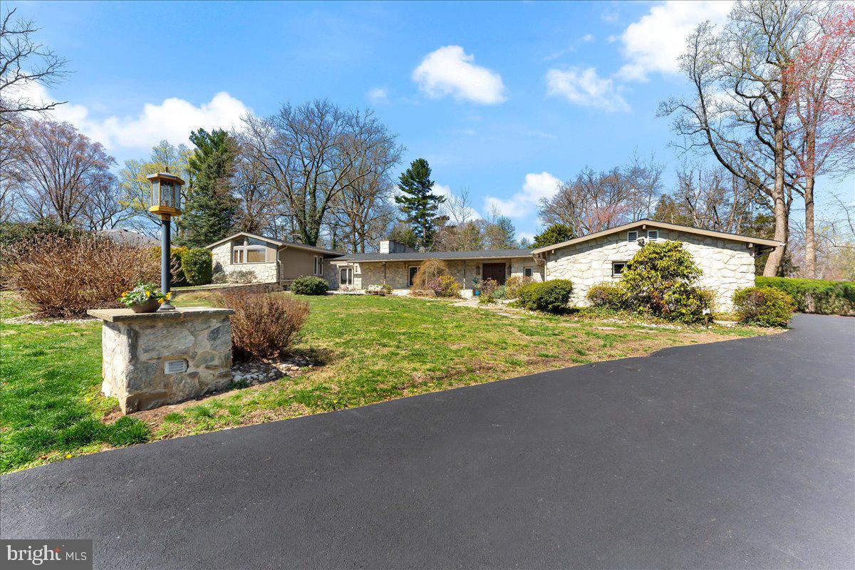 Welcome to this stunning expanded ranch rambler nestled in one of Rydal’s most beautiful and coveted neighborhoods! This expansive home offers the perfect blend of comfort, style, and convenience, located on a peaceful, tree-lined street with sidewalks.

Step inside through impressive double doors into a slate-floored hallway that flows seamlessly into an open great room and dining area. Enjoy the warmth of a gas fireplace and natural light pouring in through sliding doors that lead to your private outdoor space with flagstone pavers. The inviting living room is just ahead, ideal for relaxation and gatherings.

To the right, discover the bright eat-in kitchen featuring beautiful granite countertops, stainless steel appliances, and a cooktop oven. The kitchen also includes sliding doors, which add convenience to outdoor access. The adjacent drop-zone mudroom with excellent built-ins leads to the garage, making daily living a breeze. A lovely dining room off the kitchen enhances your hosting options, while the open-concept design keeps the space airy and bright.

A versatile in-home office/library off the living room, complete with another gas fireplace, provides a peaceful retreat for work or study.

Upstairs, a long hallway leads to the spacious primary bedroom, featuring built-in closets and a bathroom with double sinks and a shower-bath combo. A third set of sliding doors seamlessly connects the primary bedroom to the outdoors. Two additional bedrooms are equipped with their own en-suite bathrooms, offering comfort and privacy for family or guests. The fourth room boasts high ceilings and abundant natural light, perfect for a bedroom or in-home office. This home is packed with fabulous closet space throughout, especially through the upstairs hallway.

On the lower level you can find a laundry room and many large rooms offering plenty of opportunities for customization.

Recent updates include a brand new roof, repaved driveway, new sliding doors, and a refreshed kitchen floor. The main level also features a convenient powder room for guests.

Located in the sought-after Abington School District, this home is just minutes from major highways and is walkable to parks, train stations, great restaurants, and shopping, making it easy to explore the area. Residents take great pride in their homes, creating a wonderful community atmosphere.

Don’t miss your chance to own this exceptional property in a coveted enclave of Rydal—schedule a showing today!