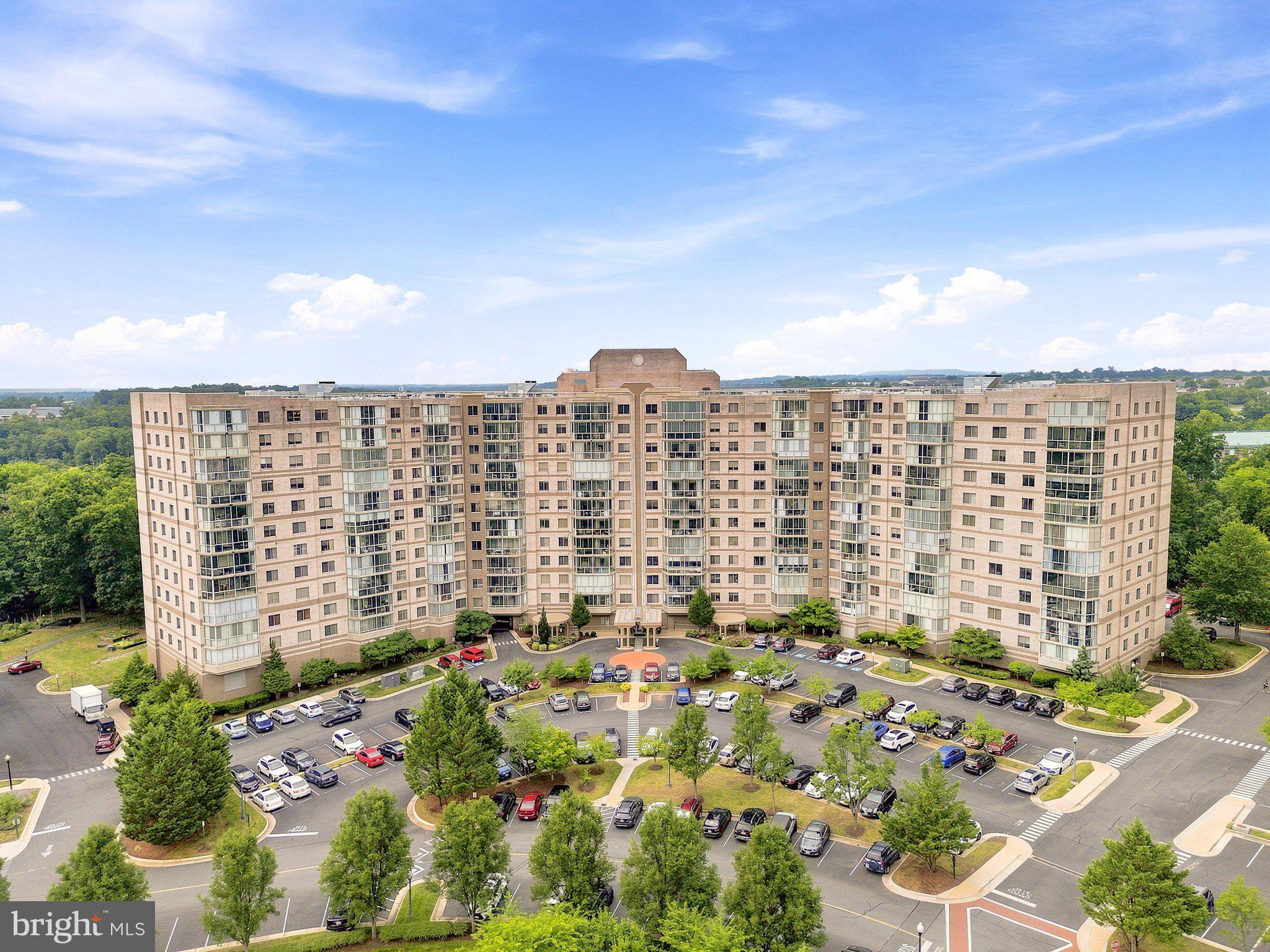 Welcome to a lifestyle where every day feels like a vacation. Nestled within the sought-after 55+ gated community of Lansdowne Woods, this beautiful Blue Ridge C+ model invites you to embrace carefree living surrounded by exceptional amenities and breathtaking sunsets. 
<br><br>
Inside, the thoughtfully designed floor plan offers effortless comfort and inviting spaces for both quiet evenings and lively gatherings. New luxury vinyl plank flooring flows through the living room, hallway, kitchen, and primary bathroom, creating a fresh, modern feel. The spacious living and dining area opens seamlessly to the sunroom. Floor-to-ceiling windows frame spectacular southwesterly views, making it the perfect place to sip your morning coffee, curl up with a good book, or end the day as the sky glows with vibrant sunset colors and community lights. The well-appointed kitchen combines functionality with style, showcasing stainless steel appliances, plentiful cabinetry, and generous workspace to accommodate everything from casual breakfasts to intimate dinner parties. For added peace of mind, the HVAC system was replaced in 2023.
<br><br>
The spacious primary suite serves as a peaceful retreat with a dressing area, two closets, including a walk-in closet, and an ensuite bath with a walk-in shower. A versatile second bedroom easily adapts to your lifestyle, whether envisioned as a welcoming guest room, home office, library, or creative studio. 
<br><br>
But the true enchantment of life at Lansdowne Woods extends well beyond your front door. This vibrant, gated 55+ community offers an exceptional, maintenance-free lifestyle where every day presents new opportunities to relax, connect, and explore. Condo fees include an impressive collection of conveniences: hot and cold water, cable TV, high-speed internet, landline service, trash removal, HVAC inspections, window washing, community transportation, and 24-hour gated security. Residents enjoy an extraordinary selection of resort-inspired amenities, including a beautifully appointed clubhouse with an indoor pool and spa, state-of-the-art fitness center, salon, rooftop tennis and pickleball courts, art and ceramics studios, woodworking shop, theater, library, billiards, non-denominational chapel, and garden plots.  An ever-changing calendar of social events, clubs, classes, concerts, happy hours, games, and special gatherings in each building, as well as in the community, makes it easy to build lasting friendships and discover new passions. 
<br><br>
Perfectly situated near the Potomac River and just minutes from golf courses, Inova Loudoun Hospital, the vibrant dining and shopping options of One Loudoun, the charming shops and restaurants of historic Leesburg, and convenient access to Ashburn, Sterling, major commuter routes, Metro, and Washington Dulles International Airport, this is a place where everyday living feels refreshingly effortless. Whether you're seeking an active social calendar or peaceful afternoons watching the sunset from your private sunroom, you'll find the perfect balance here. Welcome home to Lansdowne Woods, where carefree living meets resort-style comfort.