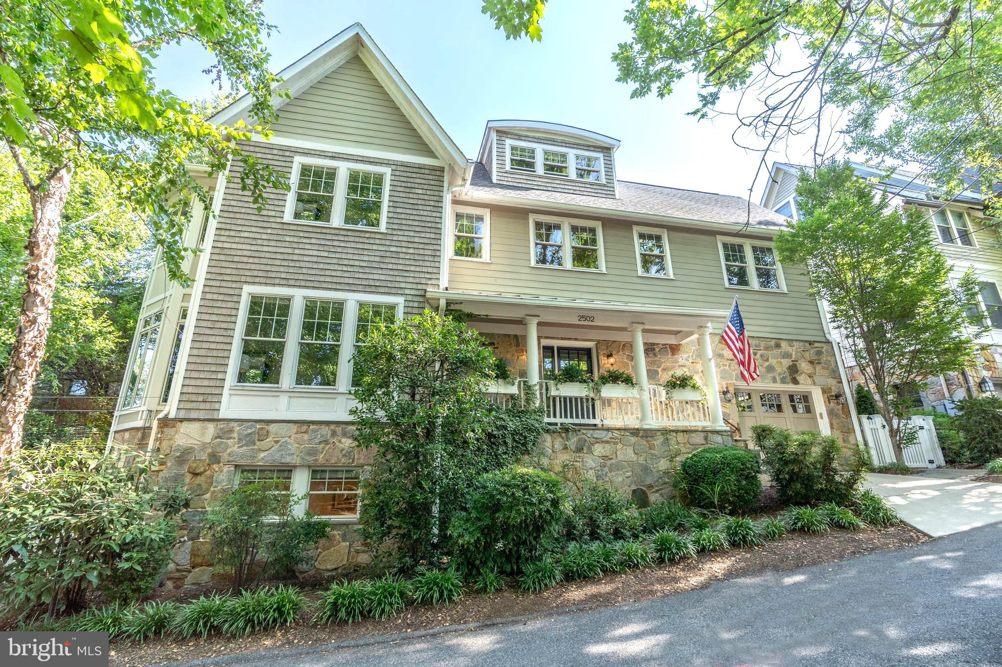 2502 Chain Bridge Road NW located at the corner of Chain Bridge and Sherier Place, mere steps to MacArthur Boulevard and Palisades Park. Evoking cues from the great summer residences of Cape Cod and Nantucket, the home was newly built from the ground up by acclaimed McCullough Construction in 2004, representing a rare example of comprehensive modern livability in an ideal close-in location. The main entrance is nestled within an inviting front porch, revealing a soaring double height foyer and showpiece grand staircase. The reception hall introduces a resplendent floor plan spanning a generous 6,318 finished square feet over four levels. Off of the foyer, a vestibule with coat closet leads to the embassy sized formal living room, accented by a roaring gas fireplace and walls of windows with verdant views. The dining room is centrally located and bridges the gap between formal and informal areas. Adjacent is a large chef’s kitchen complete with sleek shaker cabinetry, quartz countertops, a large center island with professional gas cooktop, and an integrated breakfast bar. Truly open concept, the kitchen flows seamlessly into a large family room and breakfast area. A mudroom with access to the attached garage and powder room complete the main level. On the upper level, reached via the main staircase or a full-service elevator, the primary suite occupies its own wing. It features all the ubiquitous luxury amenities including a private sitting area, twin walk-in closets, as well as a sumptuous spa bath with walk-in shower and separate jetted tub. A princess suite with spacious ensuite bath as well as two additional ample bedrooms sharing a large hall bath complete the second level. A bedroom, den and a full bath are on the top level, offering flexible space for a private office, bonus room, fitness studio, or generous storage. The lower level has a certificate of occupancy, further enhancing the home’s flexibility. A large recreation area, seventh bedroom, full bath, as well as kitchen and laundry facilities create a fully self-sufficient space. Outside, a symphony of lush landscaping and extensive hardscaping are shrouded in total tranquility. A large, tiered flagstone patio offers ample space for outdoor lounging, grilling and dining al fresco, while the fenced-in side yard is lined with maintenance-free turf and includes a basketball area. Easily walkable to eateries, Palisades Park and minutes to Georgetown as well as major commuter routes, 2502 Chain Bridge Road NW sets itself apart as a distinguished property within a highly sought after location. { Lower Level can be used for legal apartment with certificate of occupancy.}